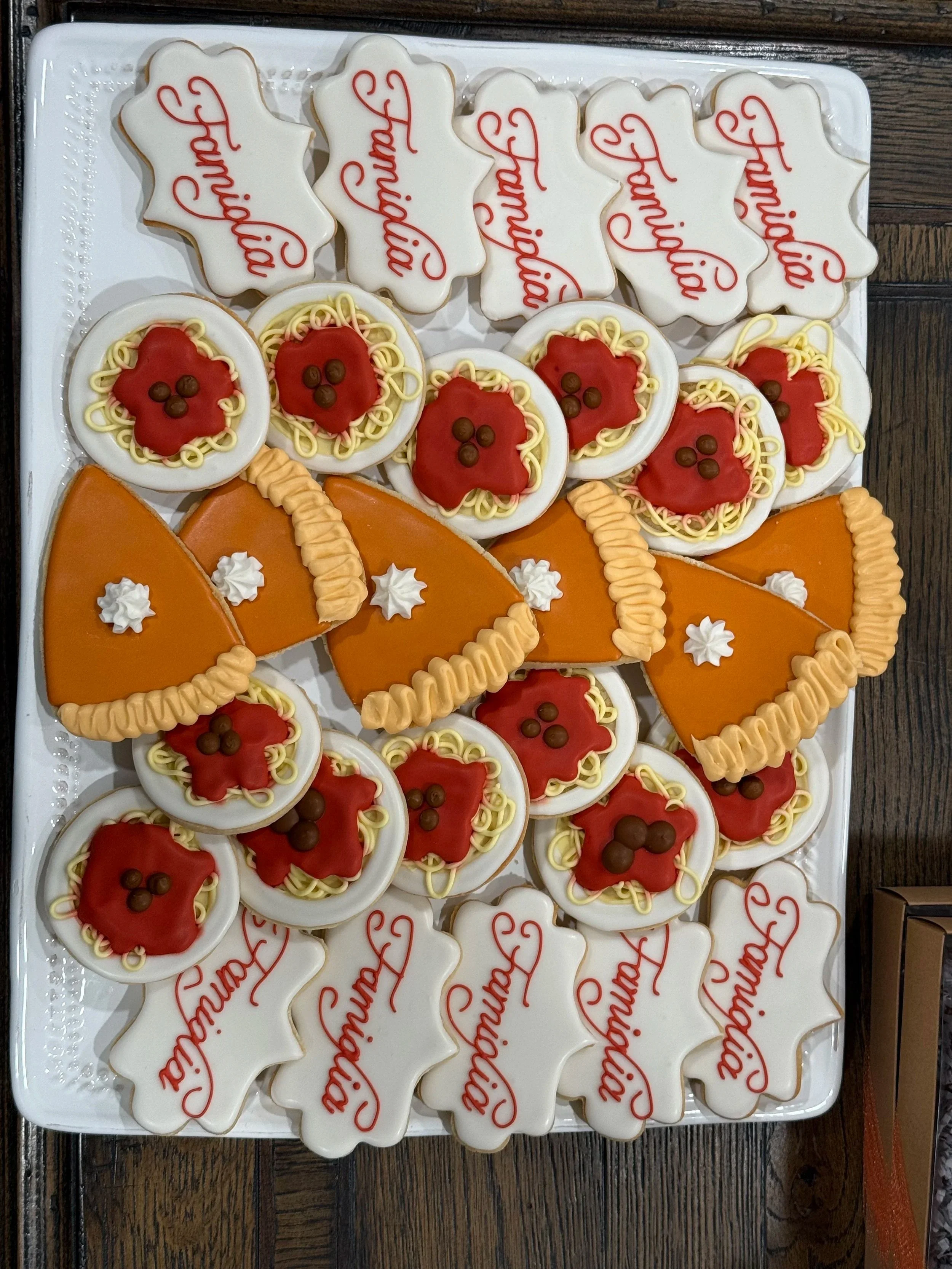 Cookies decorated for Christmas, including cookies shaped and iced as Santa's sleigh, round cookies with Santa's face, and cookies with the word 'Christmas' written in red icing.