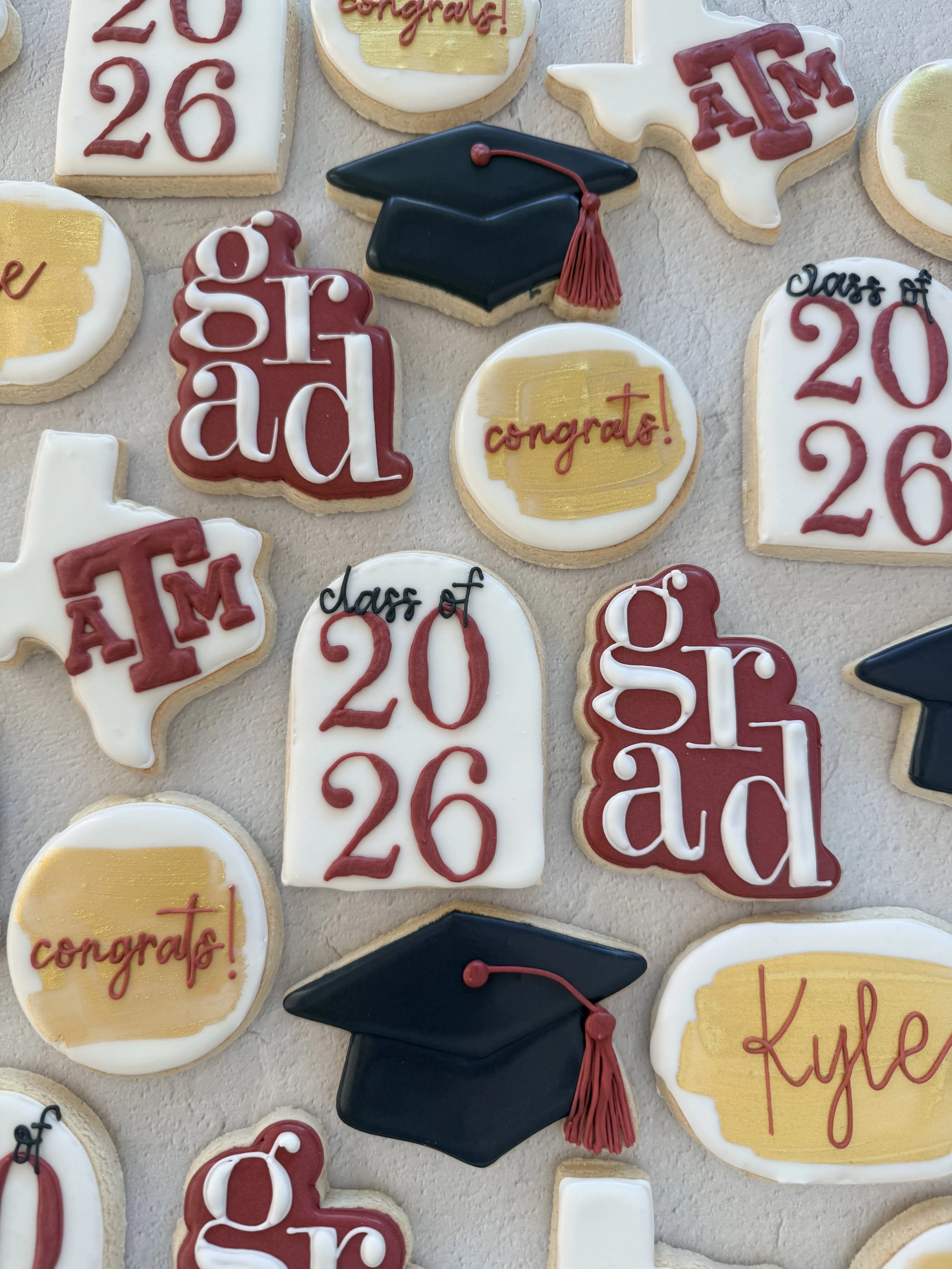 Decorated cookies for a graduation celebration featuring graduation caps, the words 'congrats!' and 'class of 2023,' and the year '2023' in red lettering.