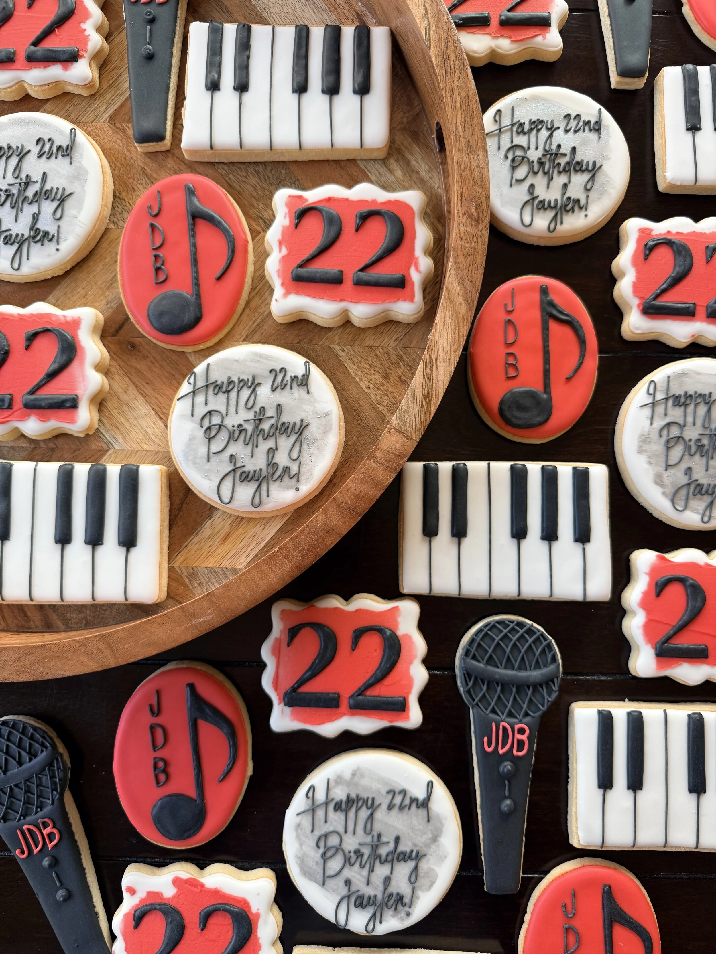 Assorted birthday cookies with musical theme, including musical notes, piano keys, and the message 'Happy 22nd Birthday Jayer!'