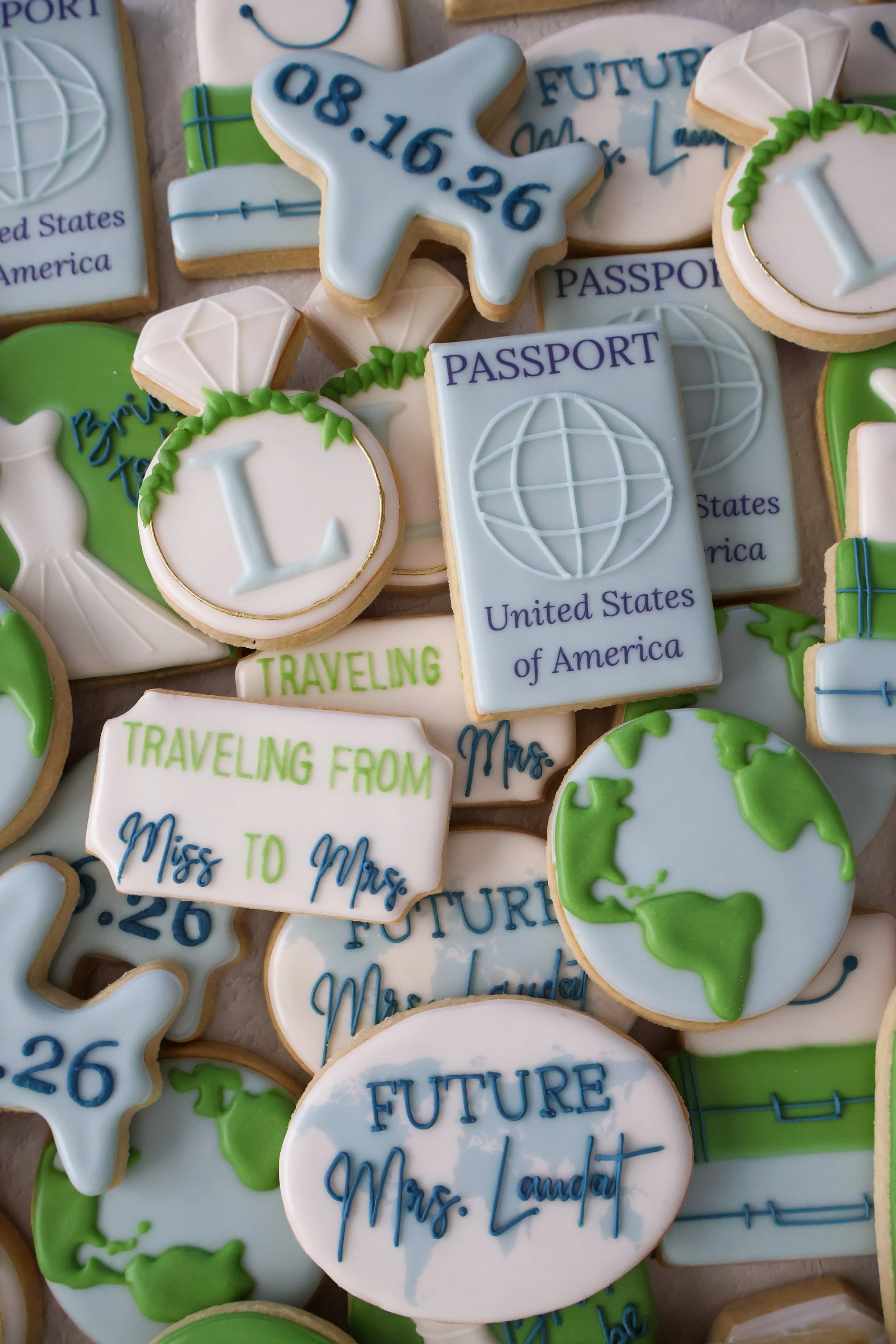 Cookies decorated with travel and passport themes, featuring images of globes, air traffic control towers, and text such as "Traveling from," "Miss to Mrs.," and dates.