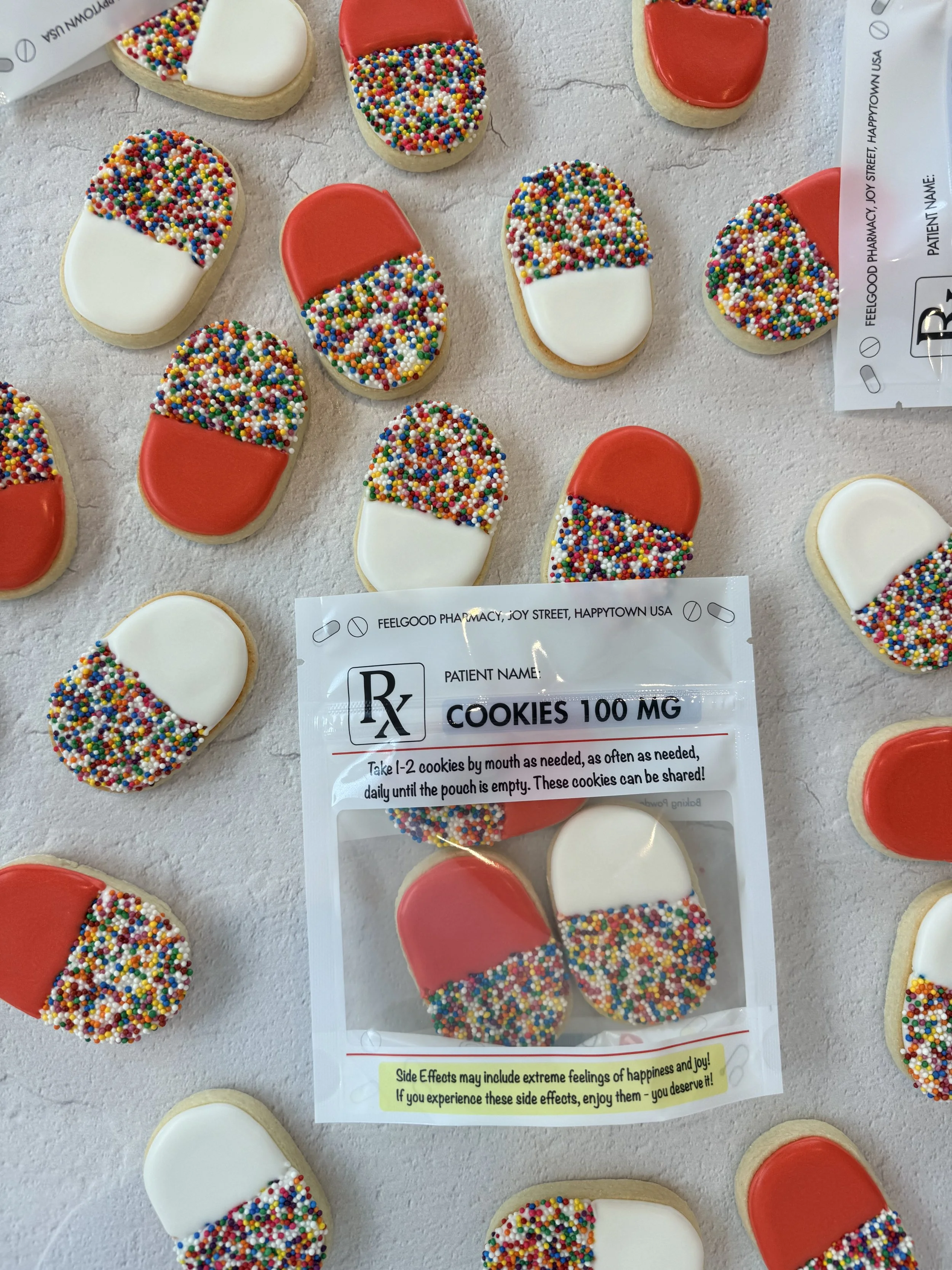 Assorted cookies decorated with white or red icing, some with colorful sprinkles, laid out on a white surface.
