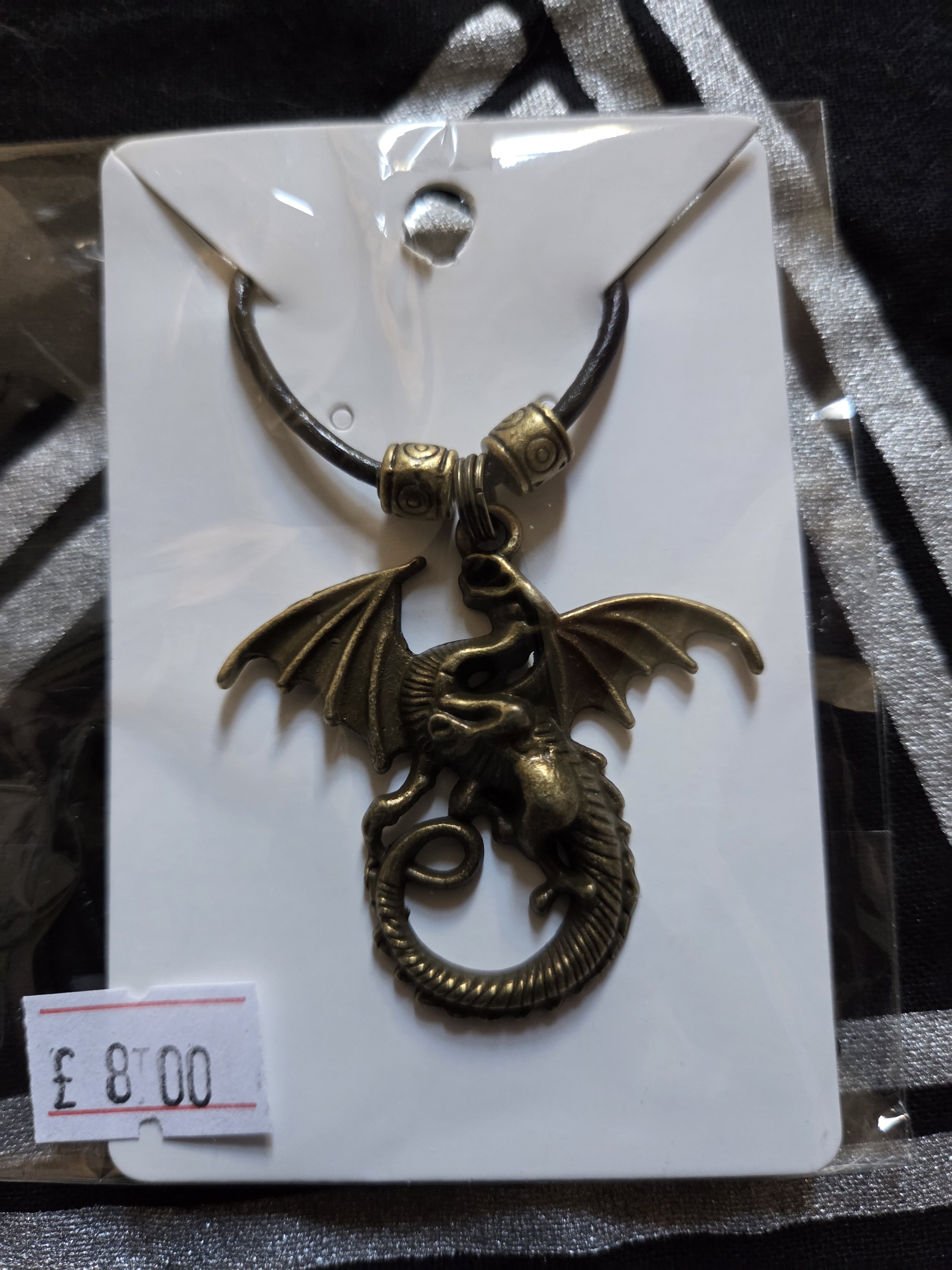 Gold dragon pendant with dark leather cord