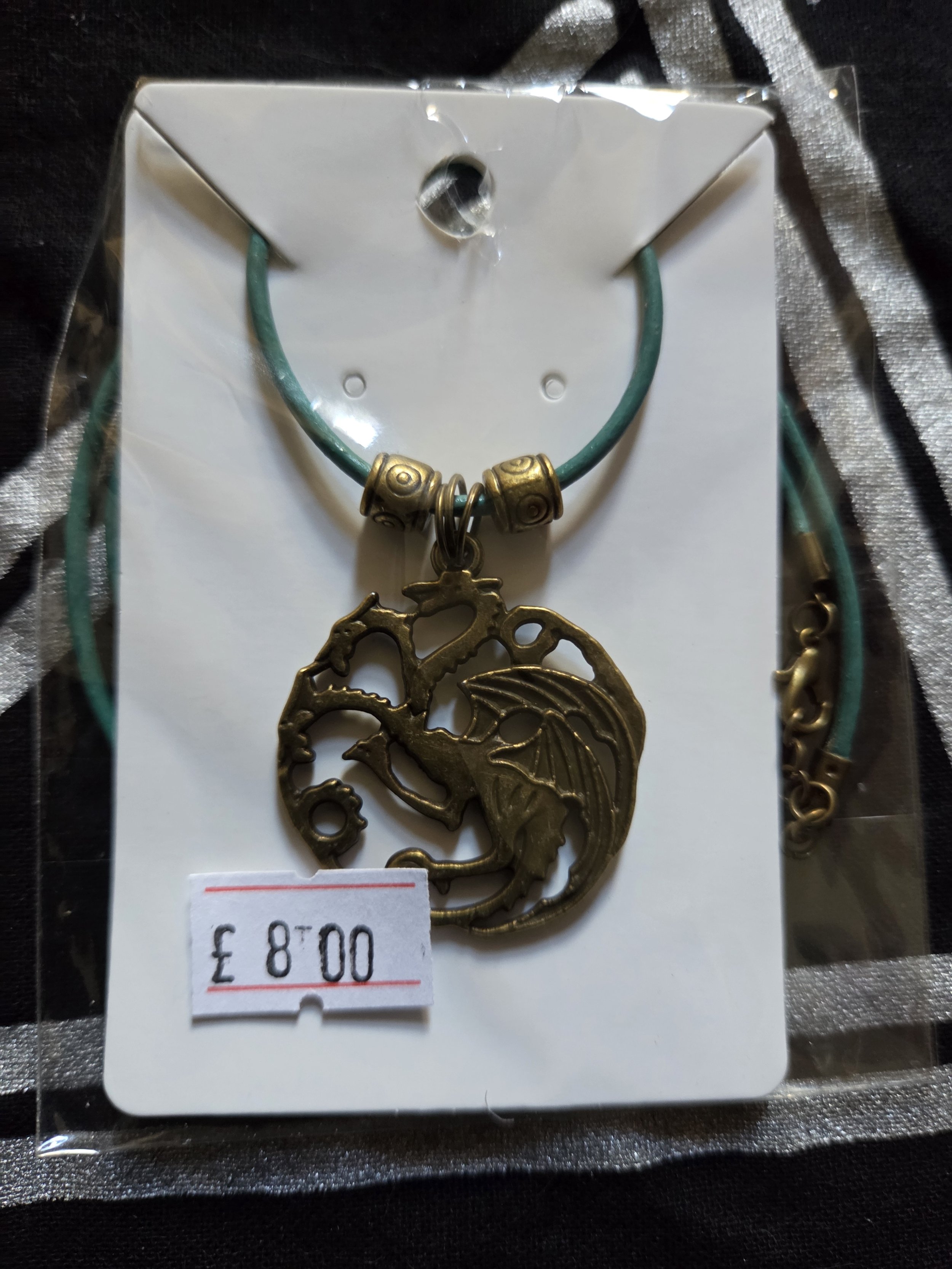 Round gold 3 headed dragon with green leather cord