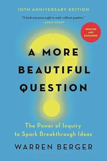 Book cover titled 'A More Beautiful Question' by Warren Berger, celebrating its 10th anniversary edition with a yellow sun graphic and a red sticker indicating 'Updated and Expanded,' subtitle reads 'The Power of Inquiry to Spark Breakthrough Ideas.'