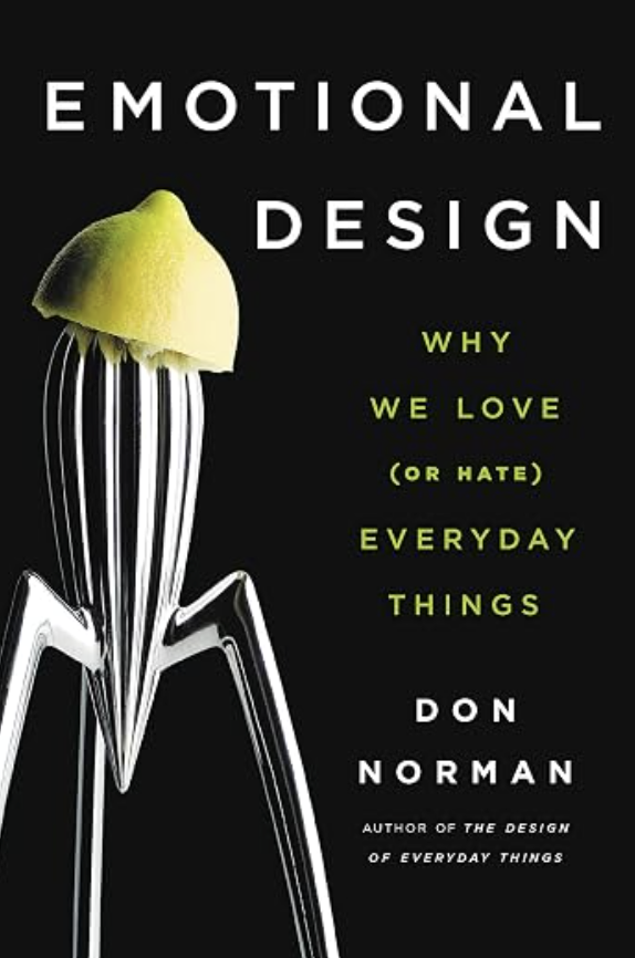 Book cover titled 'Emotional Design' by Don Norman with a black background, featuring a silver fork with a green apple slice on top, and the subtitle 'Why We Love (or Hate) Everyday Things' in green text.