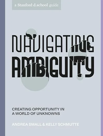 Book cover titled 'Navigating Ambiguity' by Andrea Small and Kelly Schmutte, with a subtitle 'Creating Opportunity in a World of Unknowns', published by Stanford D. School.