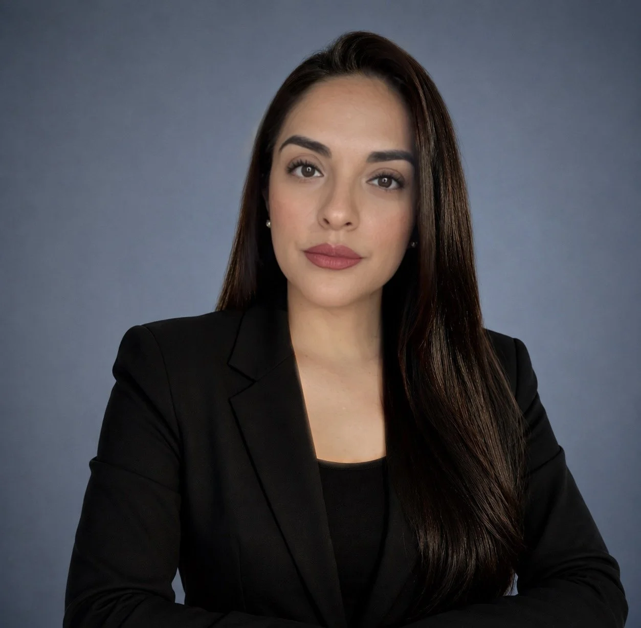 Yuliana Rimer, Founder and Executive Director of The Rimer Institution, posed against a plain blue-gray background.