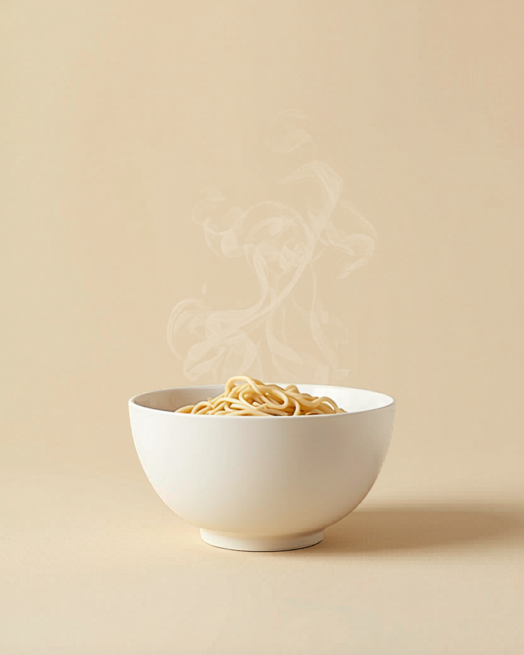 A white bowl filled with hot noodles against a plain beige background.