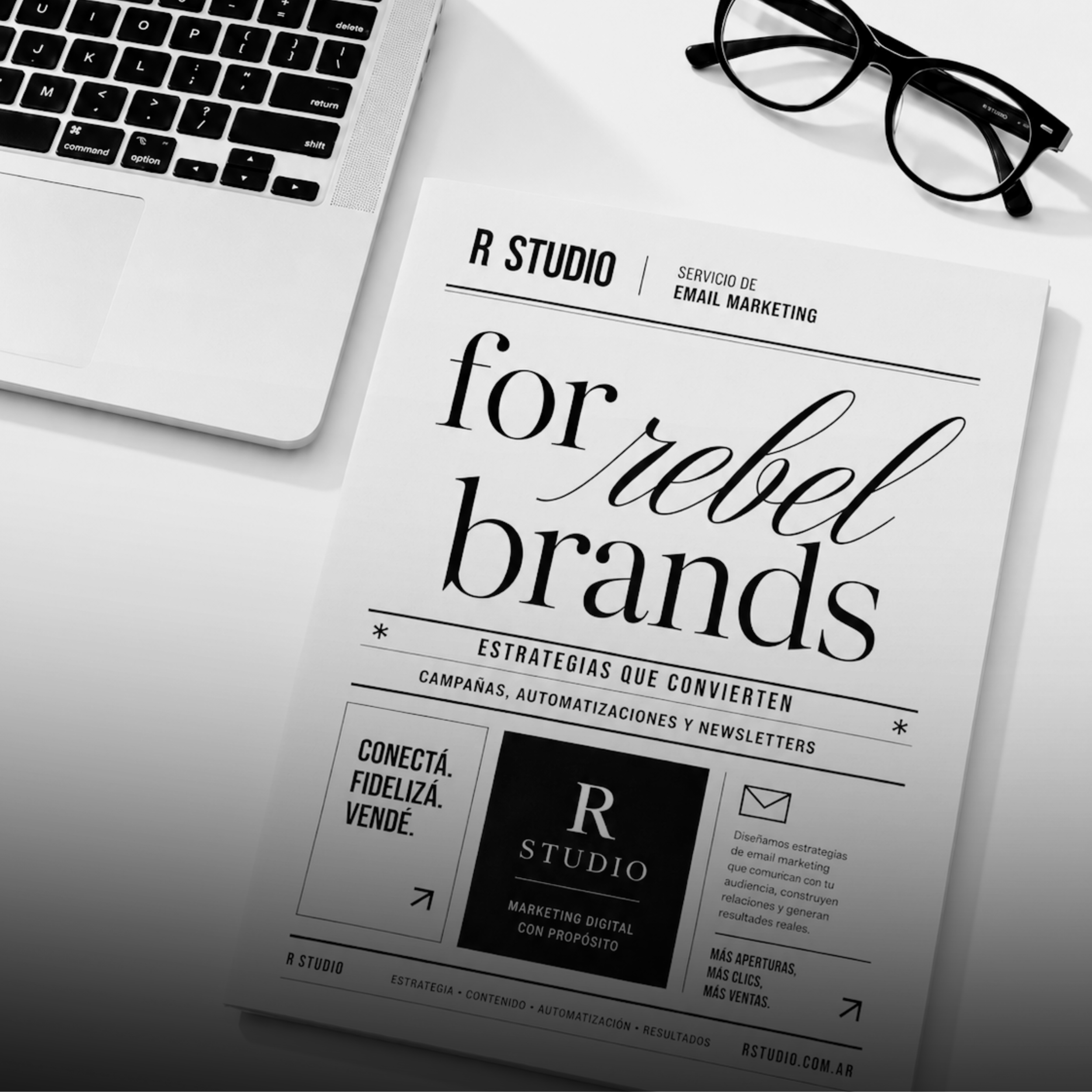 Black and white marketing flyer or brochure on a white surface, with a laptop keyboard and a pair of glasses nearby.