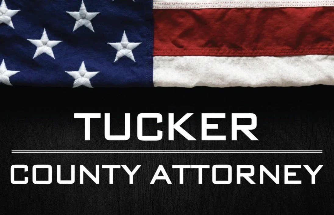 American flag above white text that says "Tucker County Attorney" on a black background.