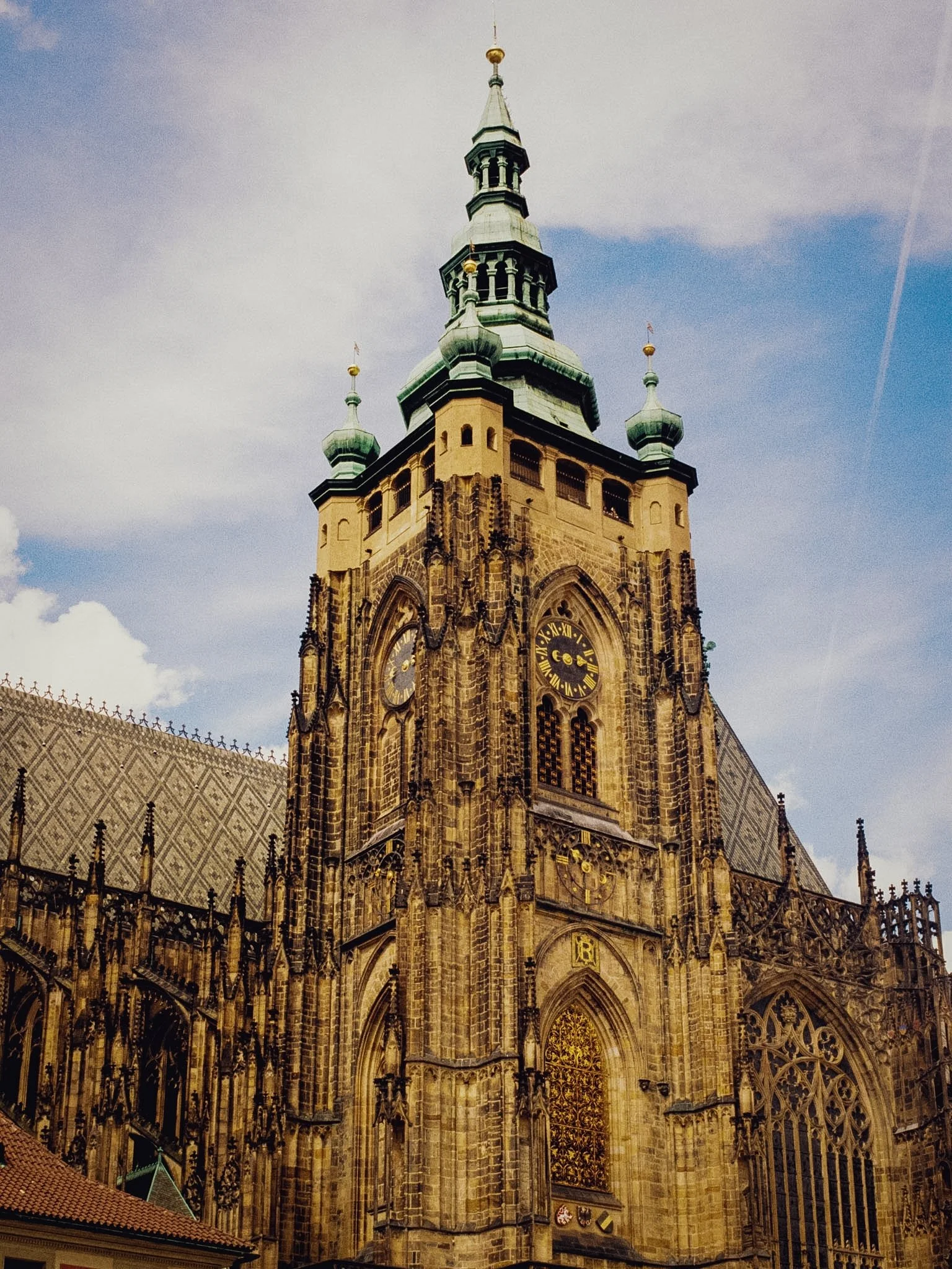 A tall historic church with gothic architecture, clock towers, and ornate windows, set against a cloudy sky.