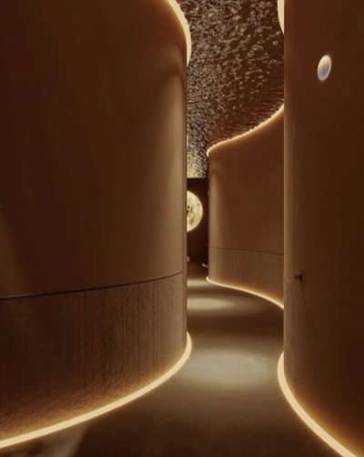 A dimly lit, modern hallway with curved walls and ceiling, illuminated by soft, warm lighting along the base and edges.