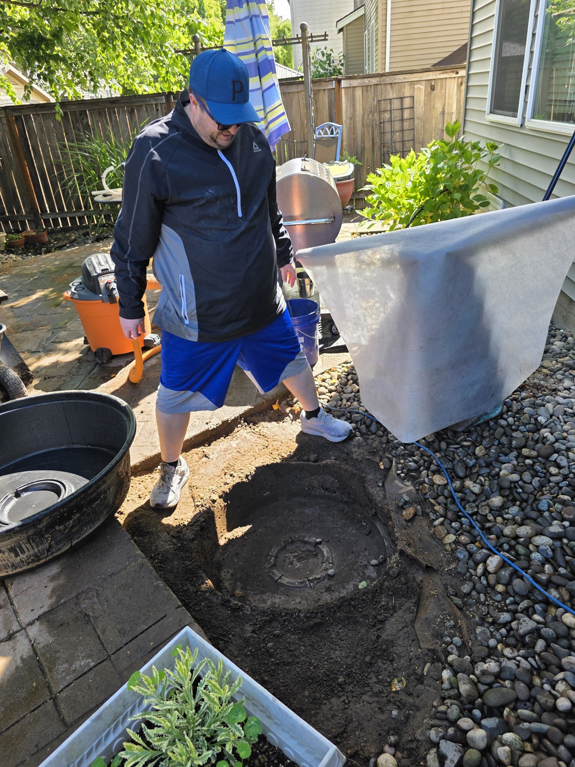 Kurt standing over dirt compacted in the shape of the bottom of the pond