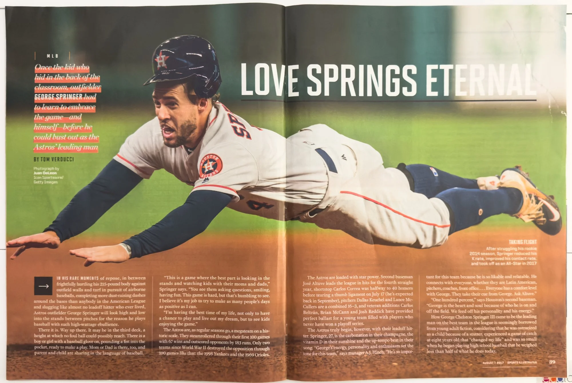 A baseball player from the Houston Astros diving on the field during a game.
