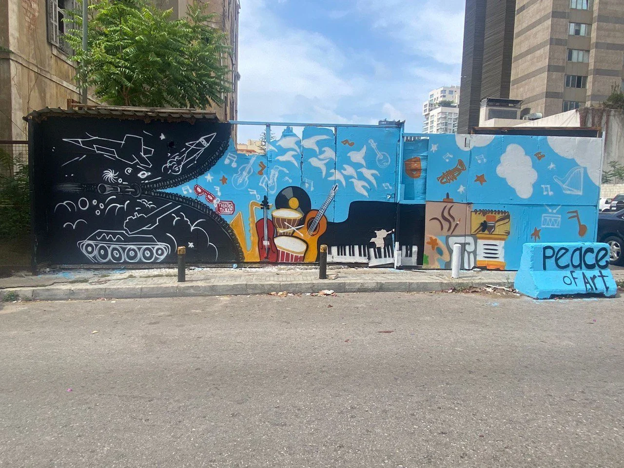 Colorful mural on a wall featuring musical instruments, a piano keyboard, and the words 'Peace of Art' on a blue section.