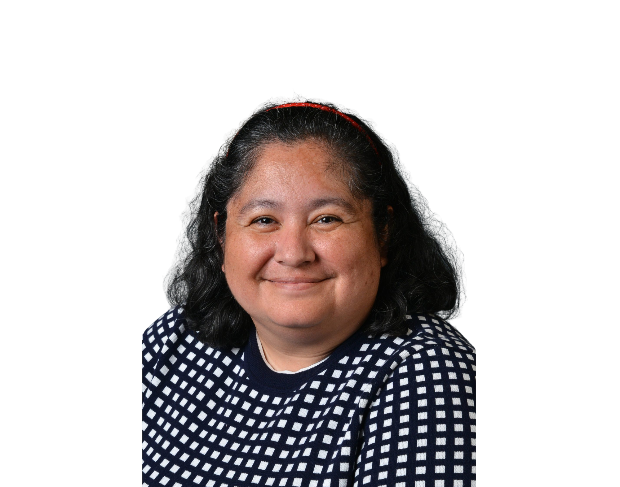 A woman with black, wavy hair smiling, wearing a blue and white checkered sweater, against a plain white background.