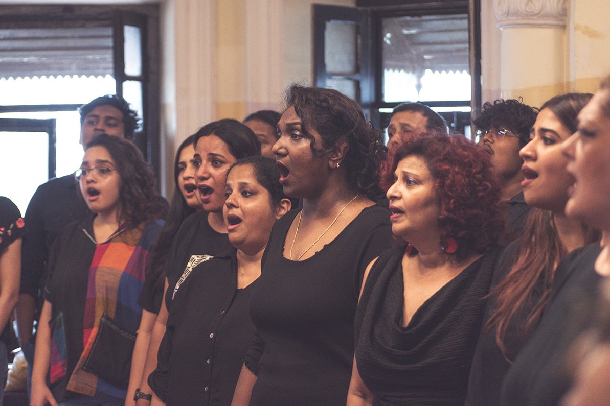 Group of women singing together in a room.