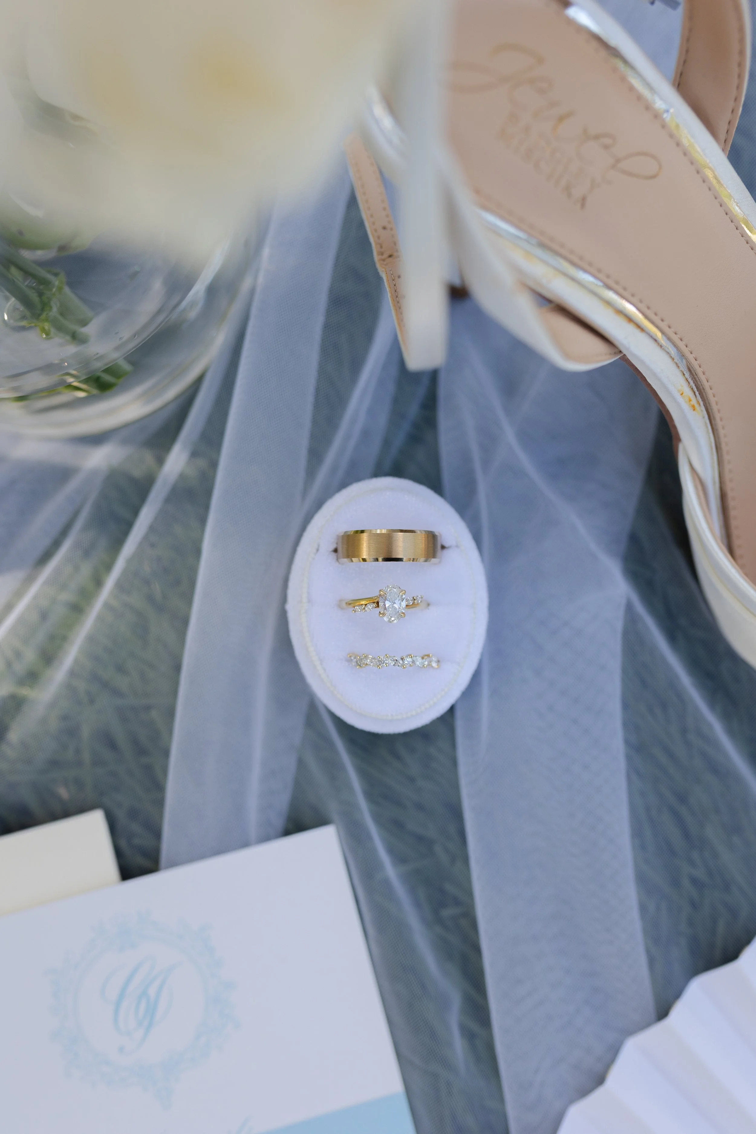 A jewelry box containing a gold wedding band and a diamond engagement ring.