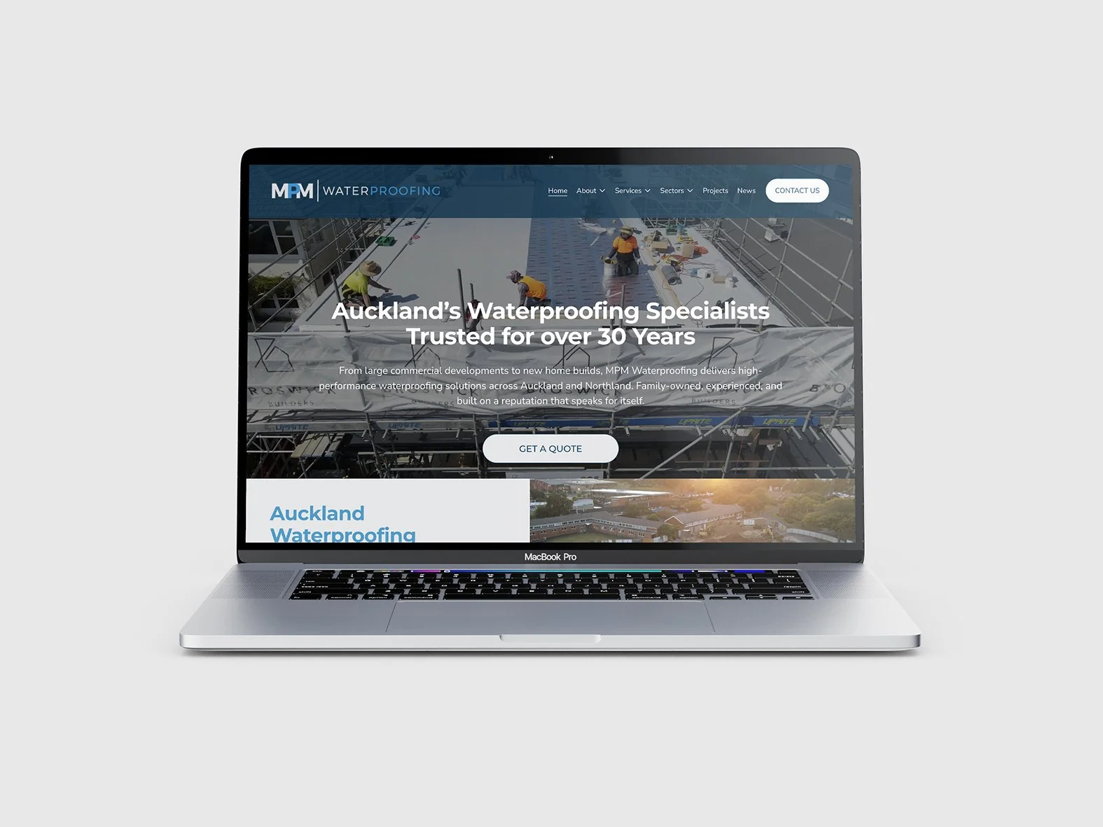 Screenshot of a laptop displaying a website for waterproofing services, showing workers on a roof with scaffolding and a scenic sunset view.