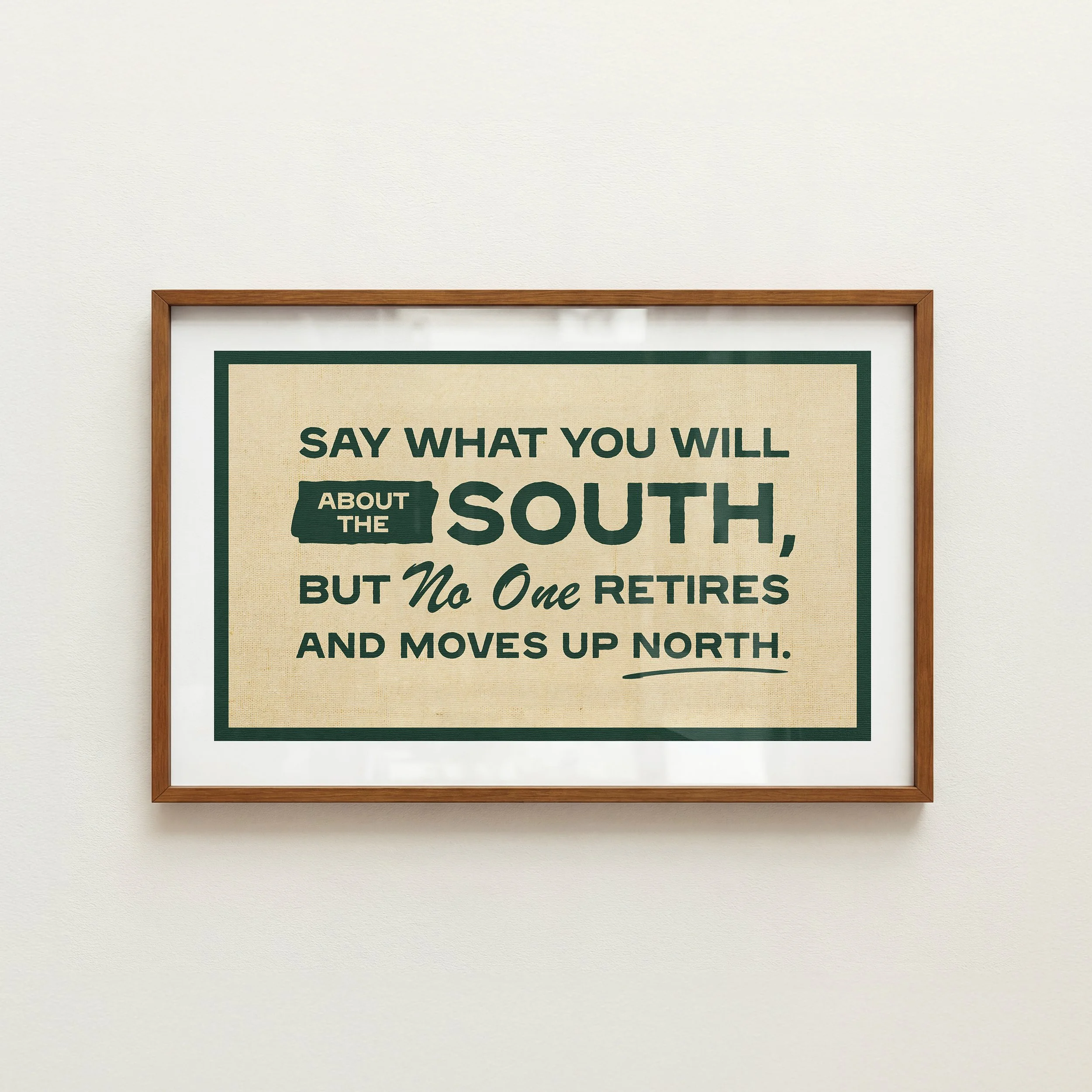 Framed poster with text about the South, on a white wall.
