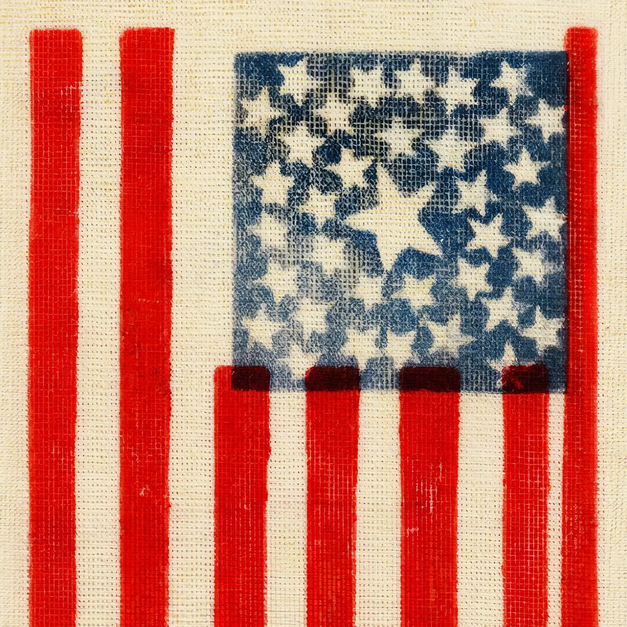Close-up of a cross-stitch depiction of the American flag with red and white stripes and a blue field with white stars.