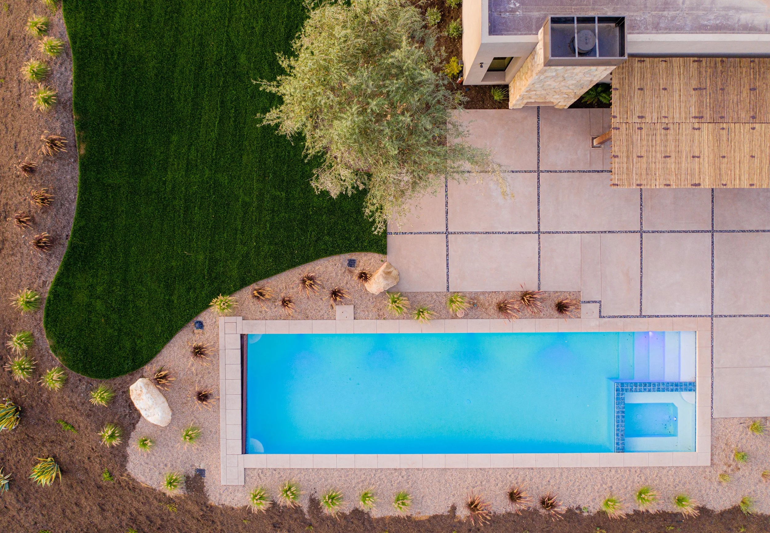 birds eye view of a rectangle pool surrounded by landscaping