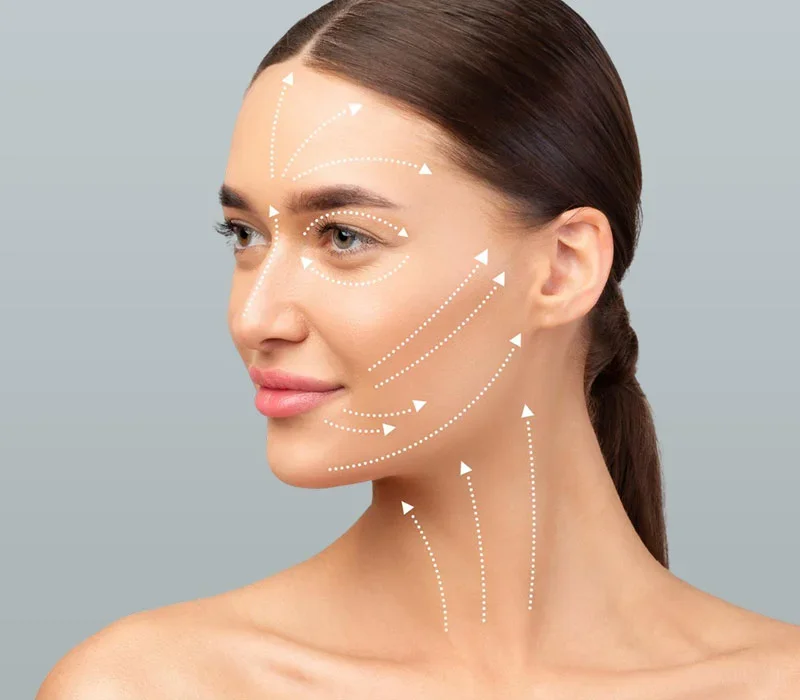 Close-up of a woman with arrows indicating facial massage or skincare directions.