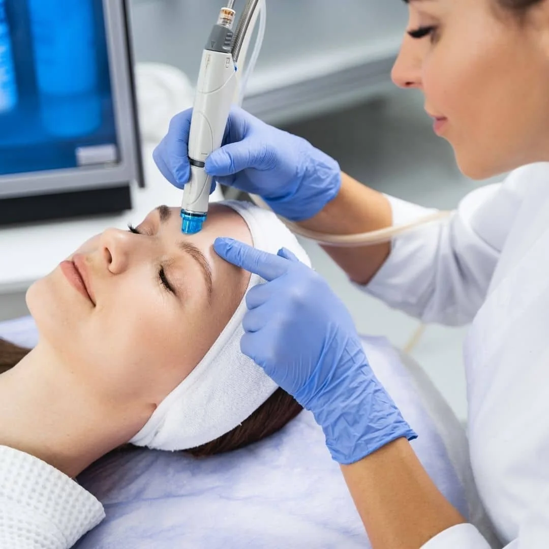A woman receiving a cosmetic facial treatment from a professional in a medical clinic.