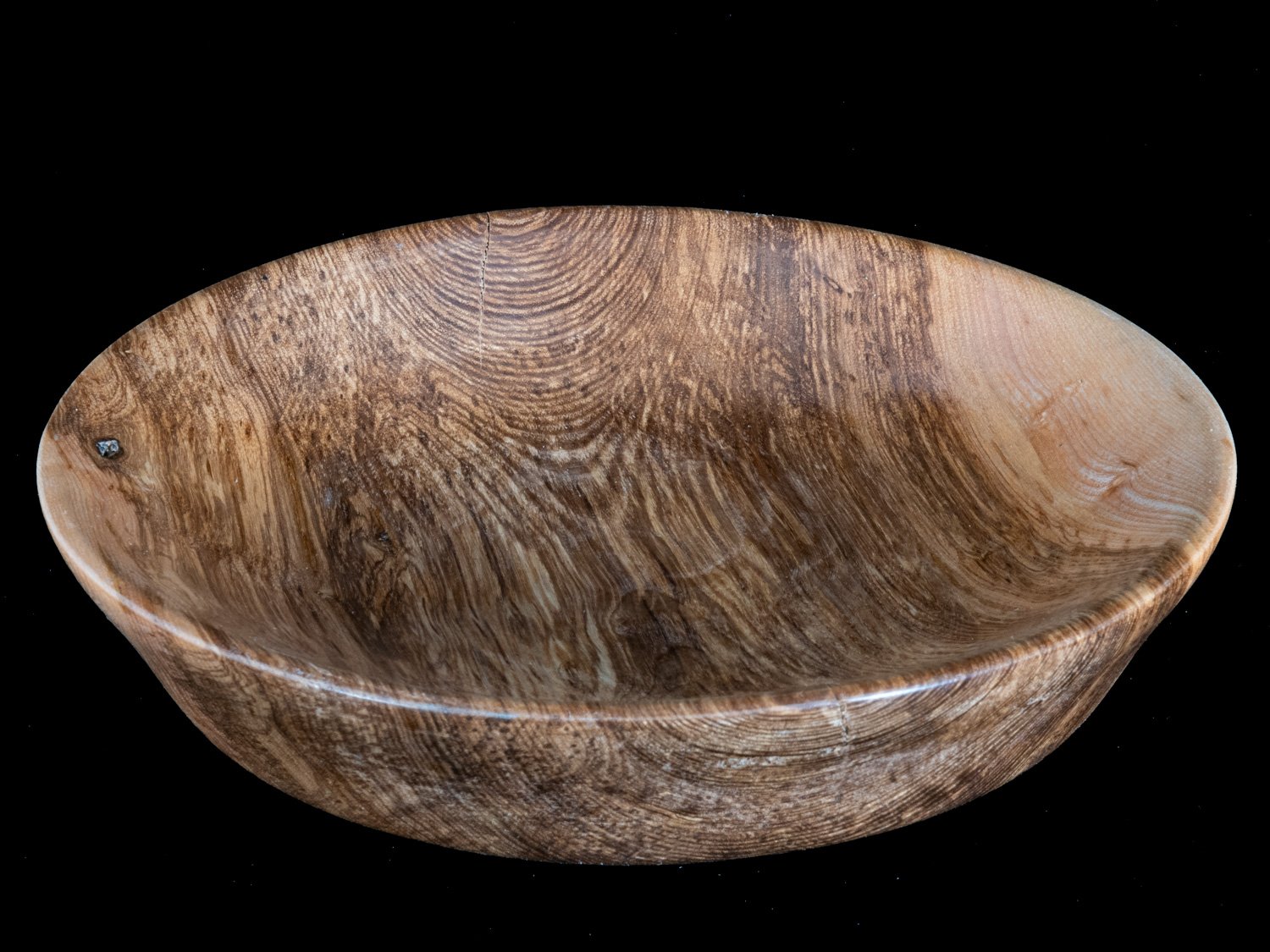 A wooden bowl with a natural wood grain pattern, set against a black background.
