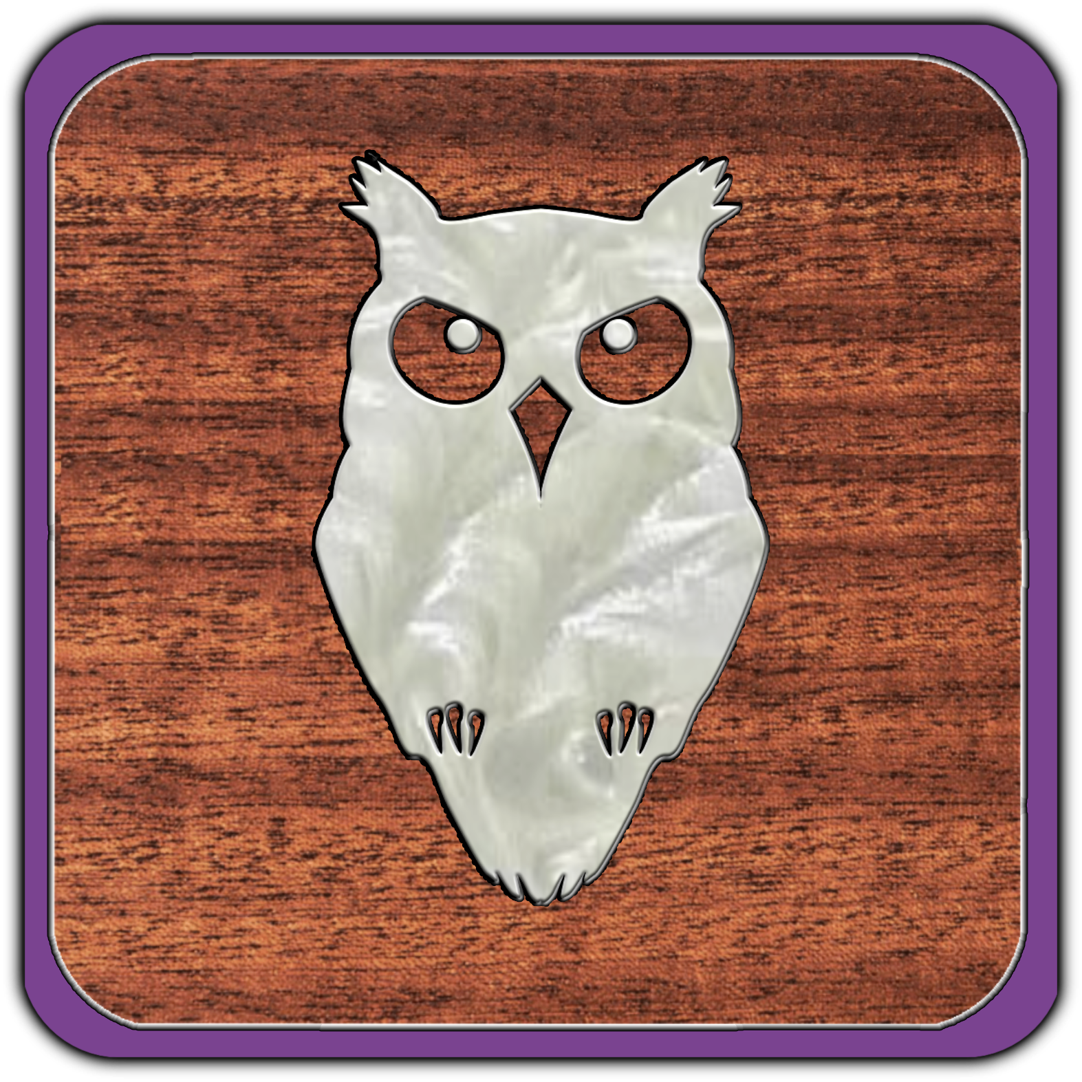 A metallic owl-shaped object mounted on a wooden surface.