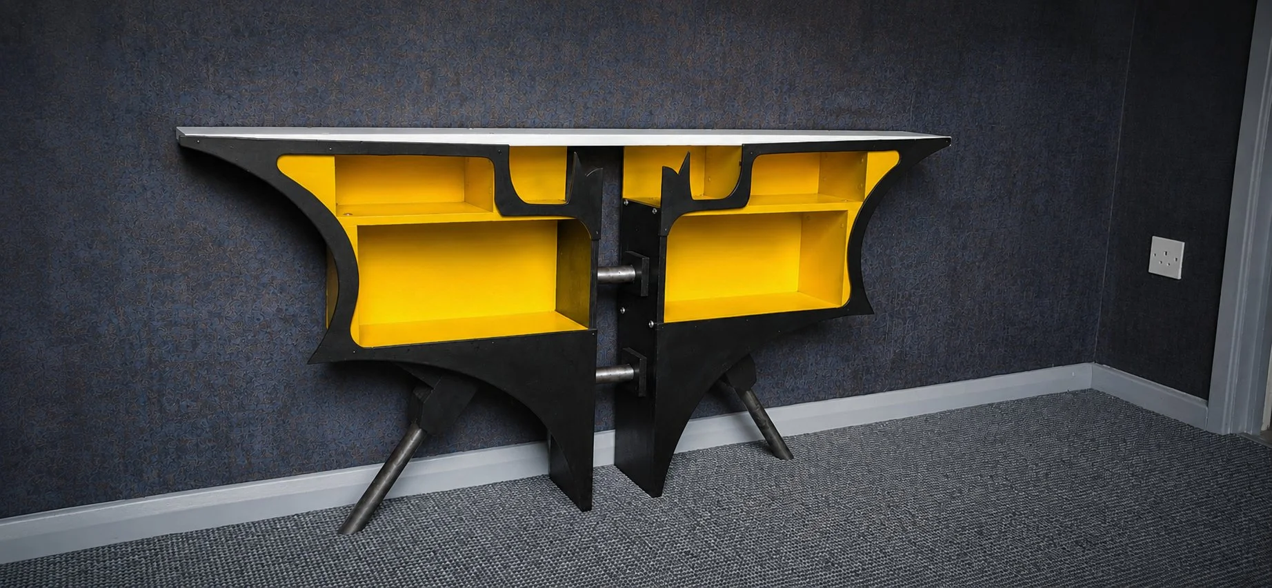 The piece needed to feel like it belonged in his man cave, rather than looking like a conventional bookcase. Huge DC and Marvel fan.