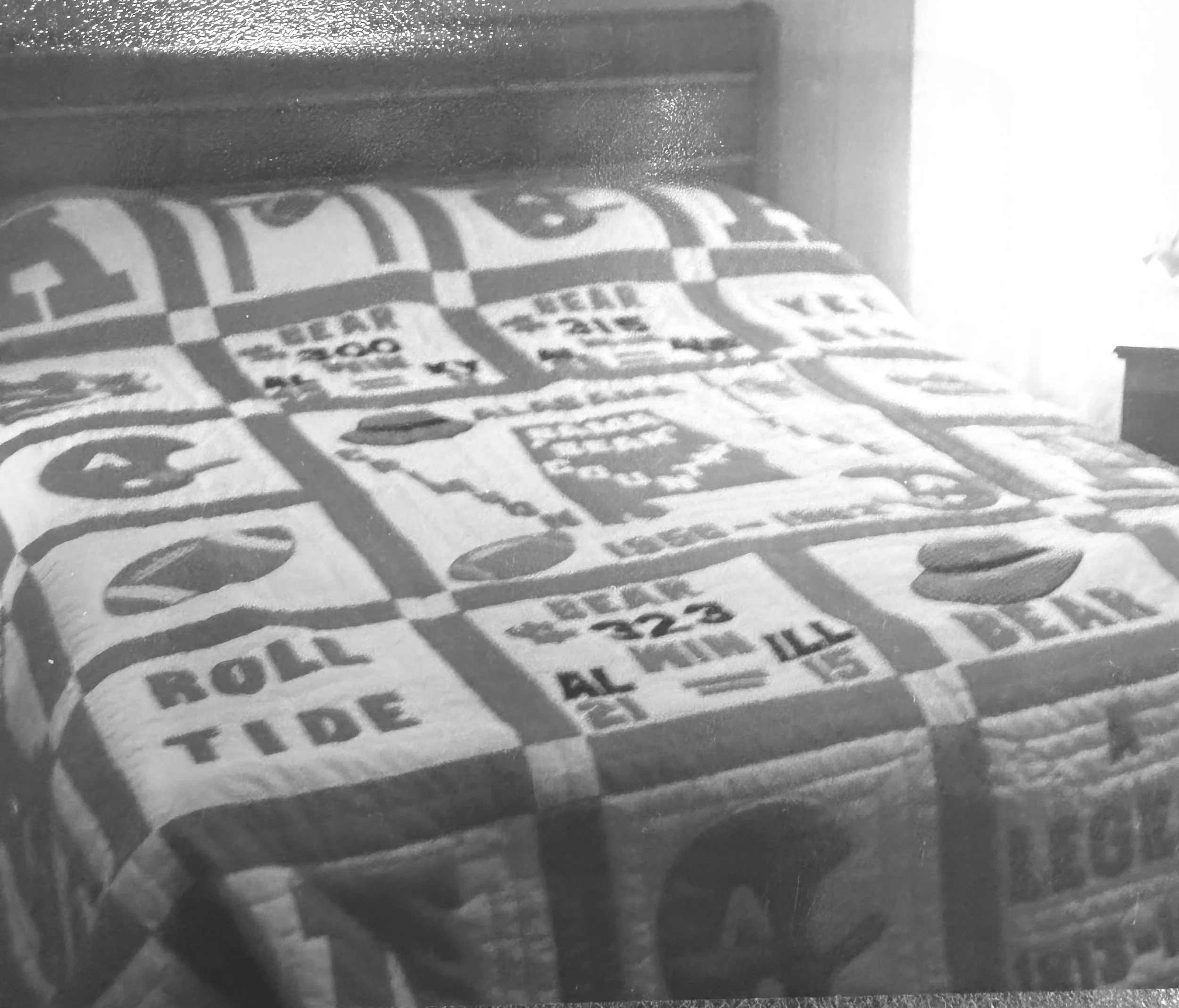 Black and white photo showing a handmade Alabama Football quilt, southern quilting bee.