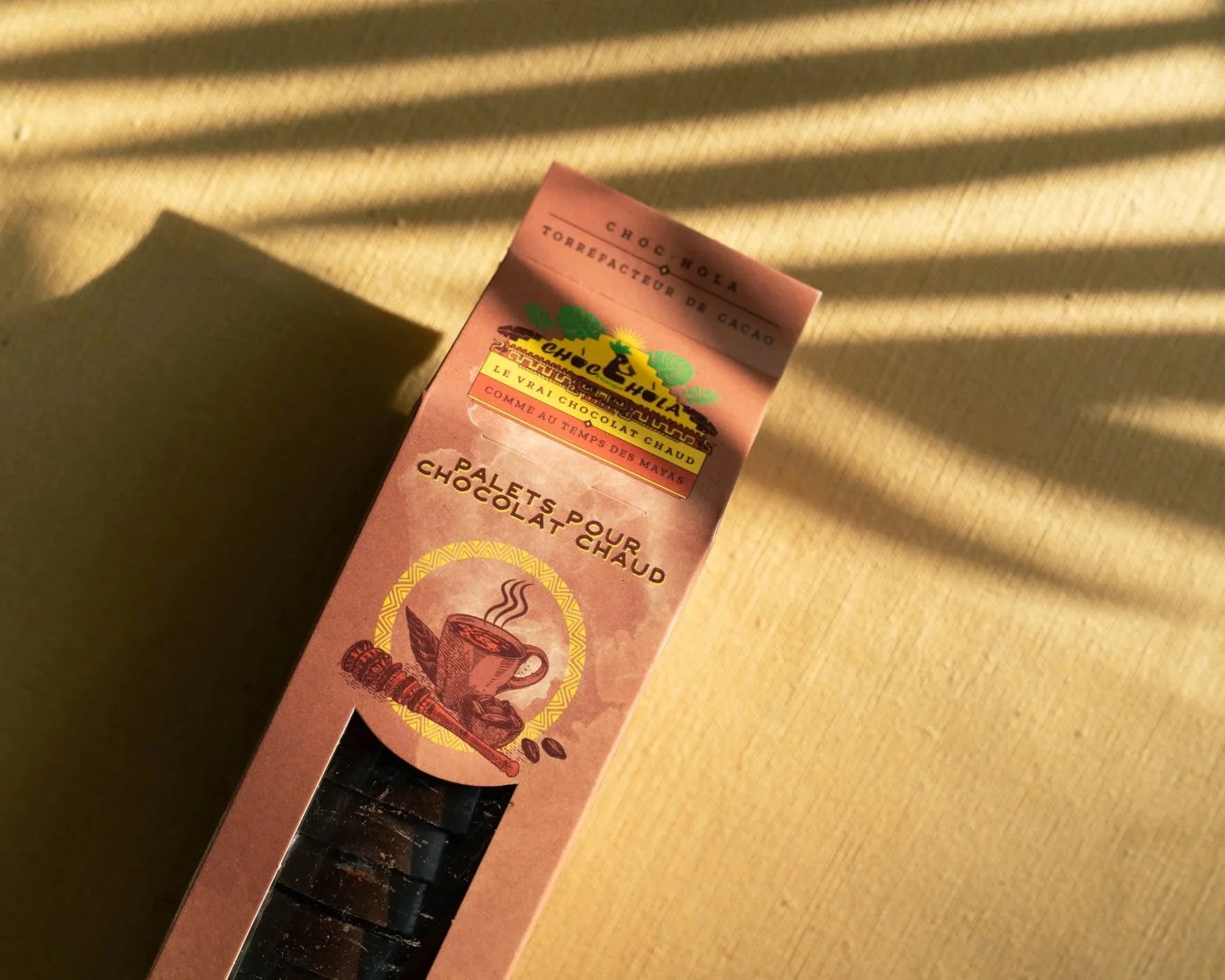 Boîte de chocolat chaud avec illustration d'une tasse de chocolat chaud et de grains de café, etiquetée 'Chocolat chaud'.