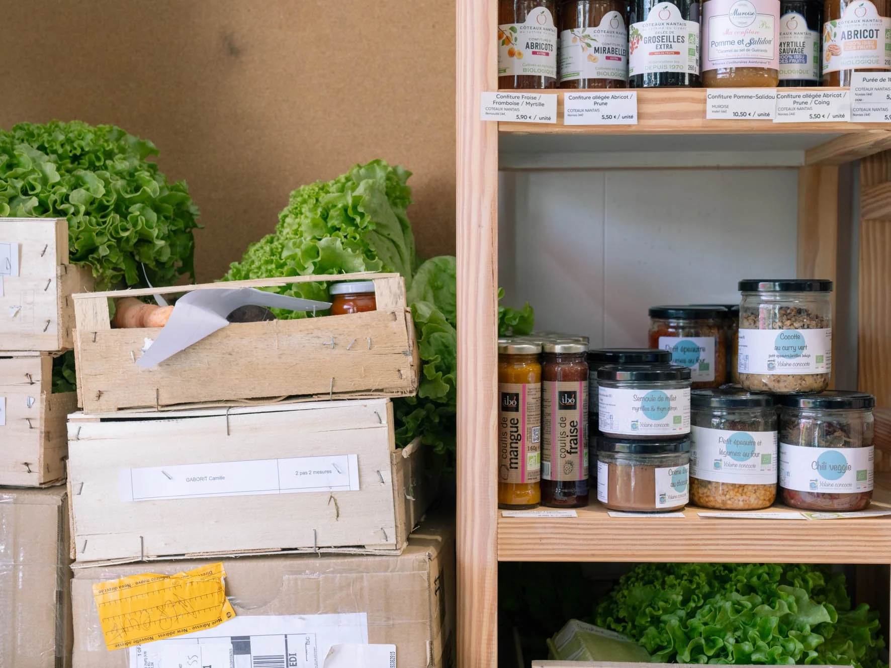 Étals de légumes verts et bocaux de confitures et autres produits bio dans une épicerie ou marché biologique.