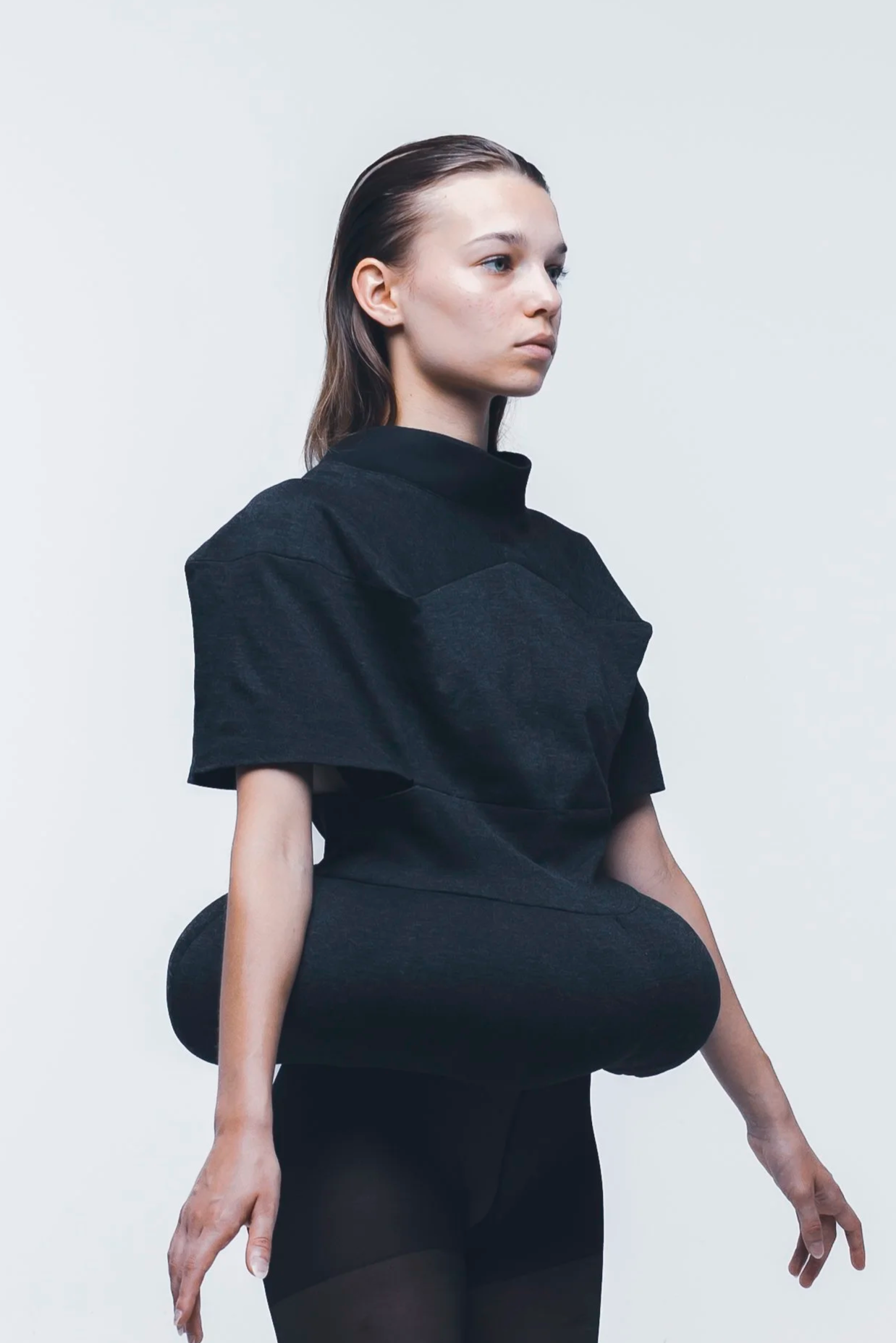 Silhouette "Bouée" noire créée par Louise Aguilar, caractérisée par un volume circulaire structuré à la taille et une construction minimaliste.