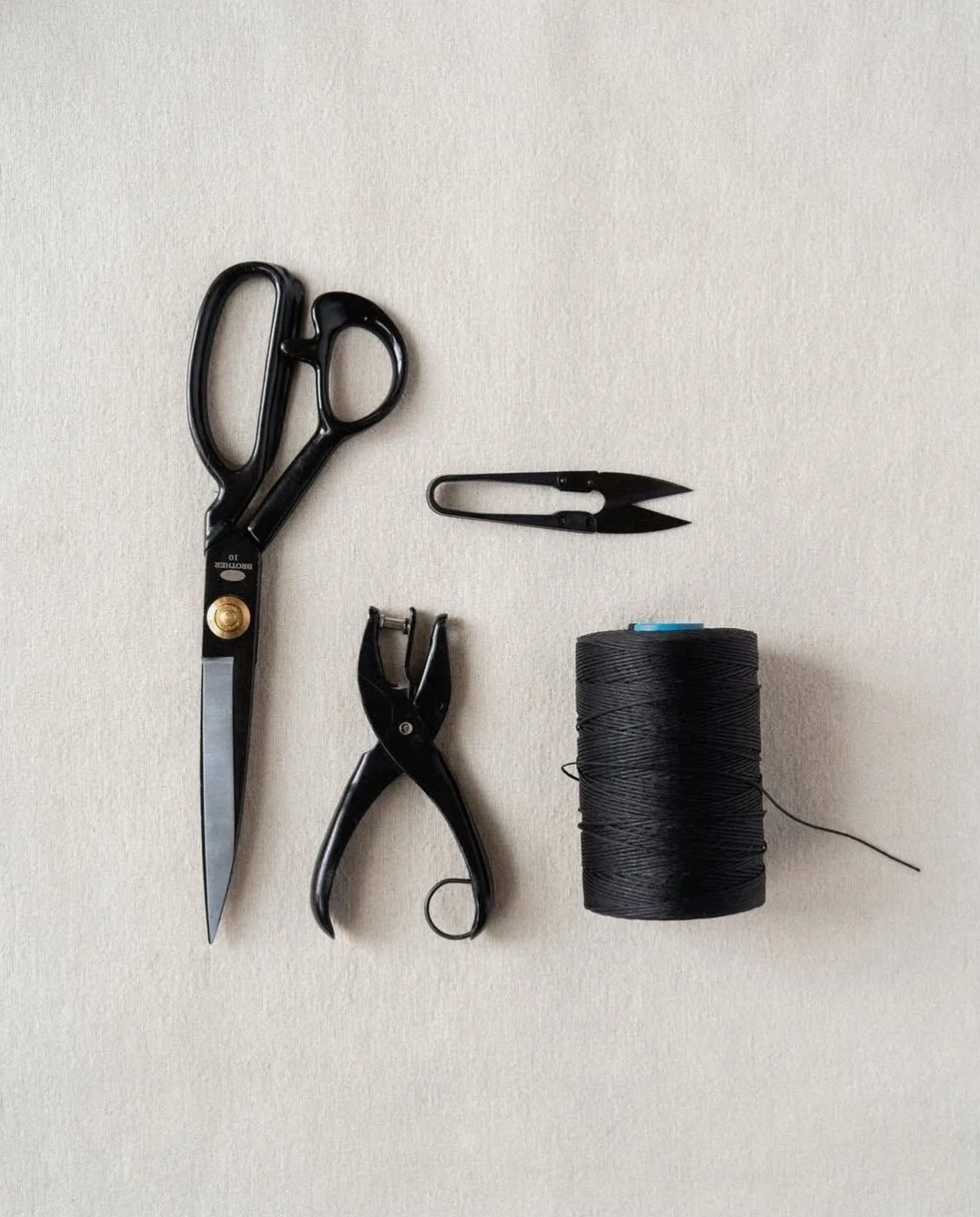Couteau, ciseaux, épingles, fil noir, pince à linge