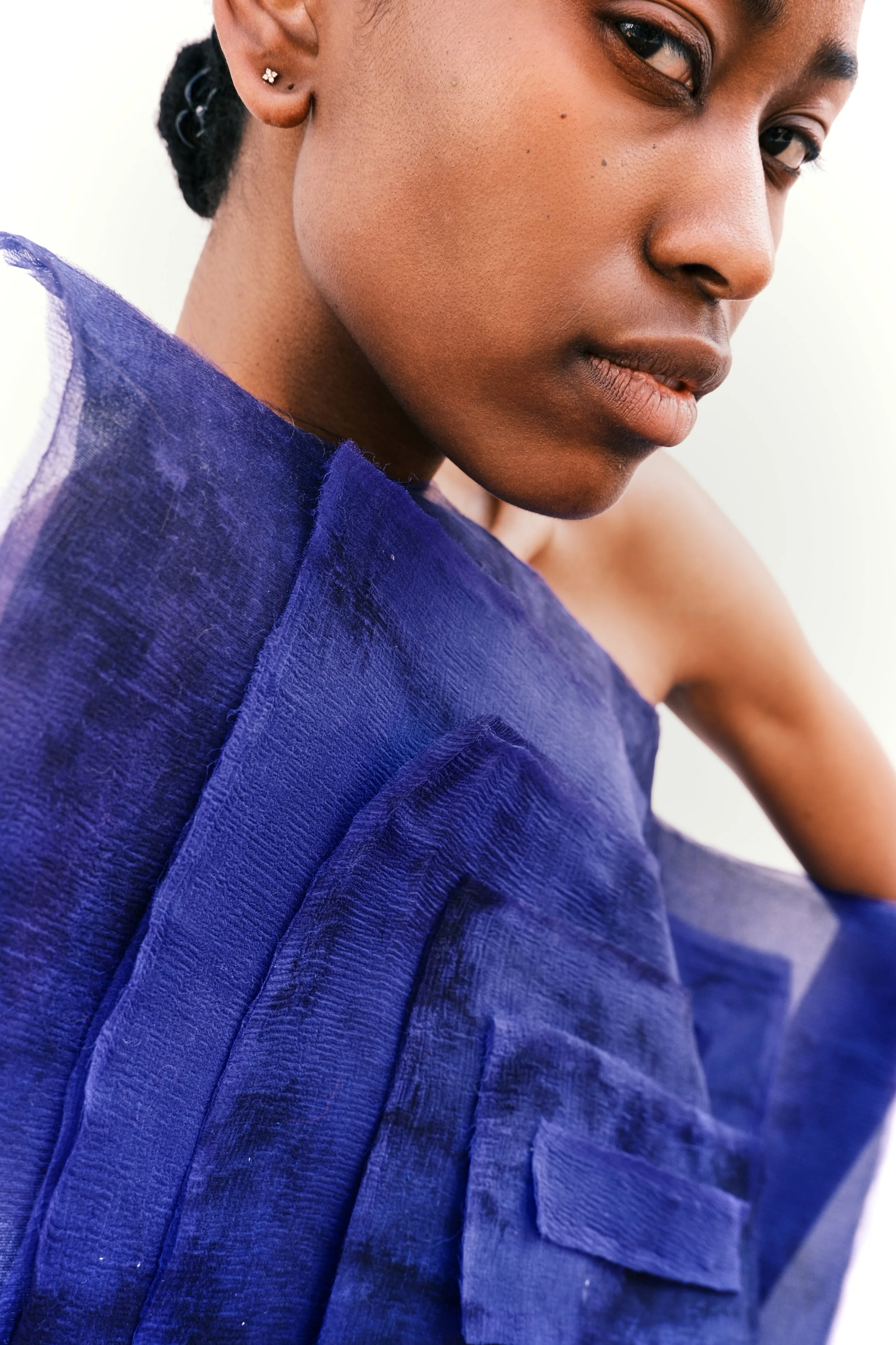 Détail de la silhouette expérimentale « Bleu Turrell » en organza noir plissé conçue par Louise Aguilar, explorant la perception visuelle et les jeux de volume.