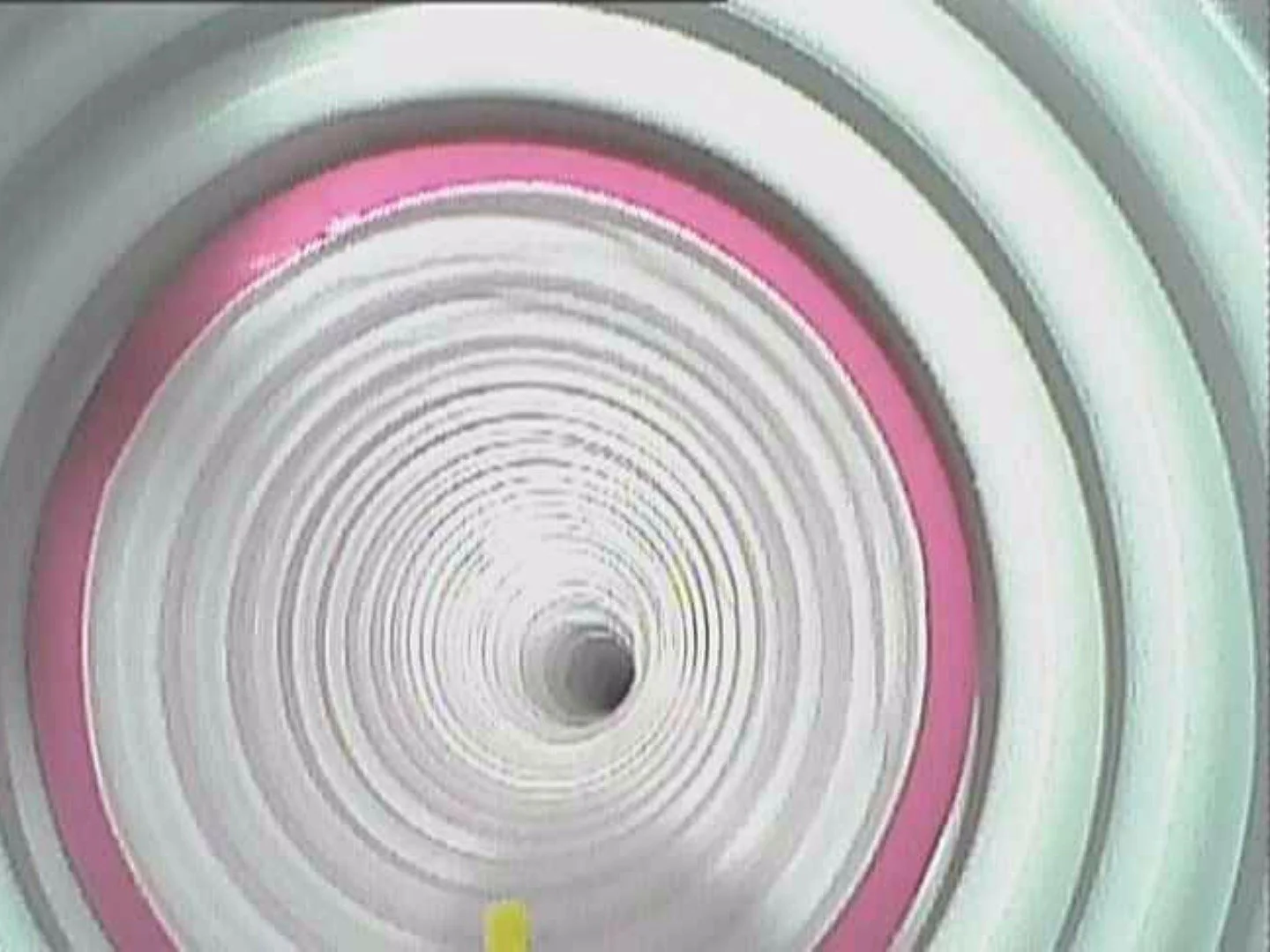 A photograph of a multi-colored, circular tunnel with concentric rings in shades of pink, gray, and white, creating a spiral effect.