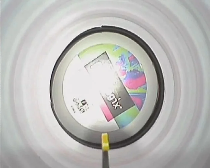 View inside a roll of colorful tape showing a partial label with the word "XOX" and a colorful abstract design.