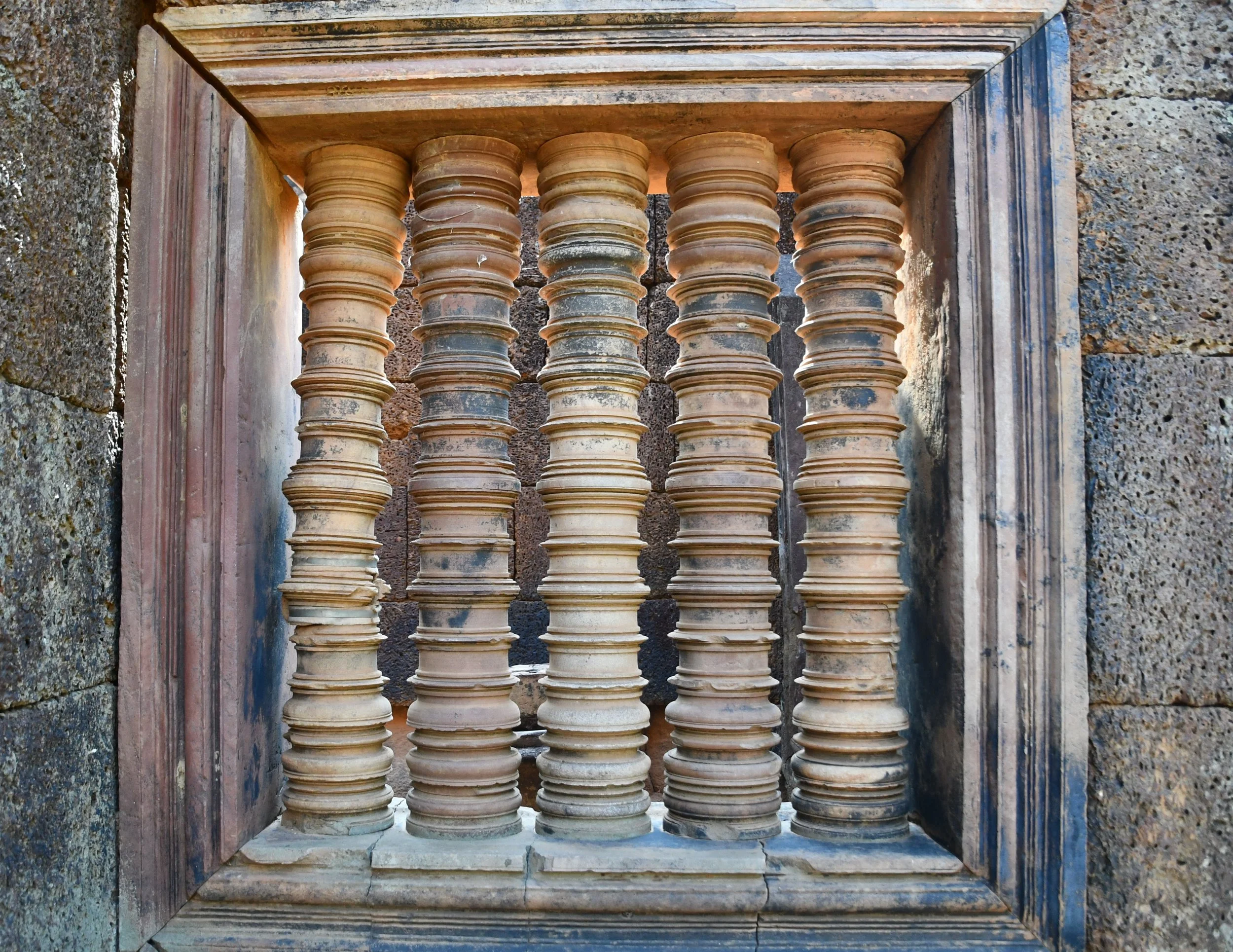 Photo by Gretchen Martens of pillars in a window at Angkor Wat in Cambodia, speaking to the pillars for stories as vessels for becoming, Red Tent Press, and its series Stories from the Threshold