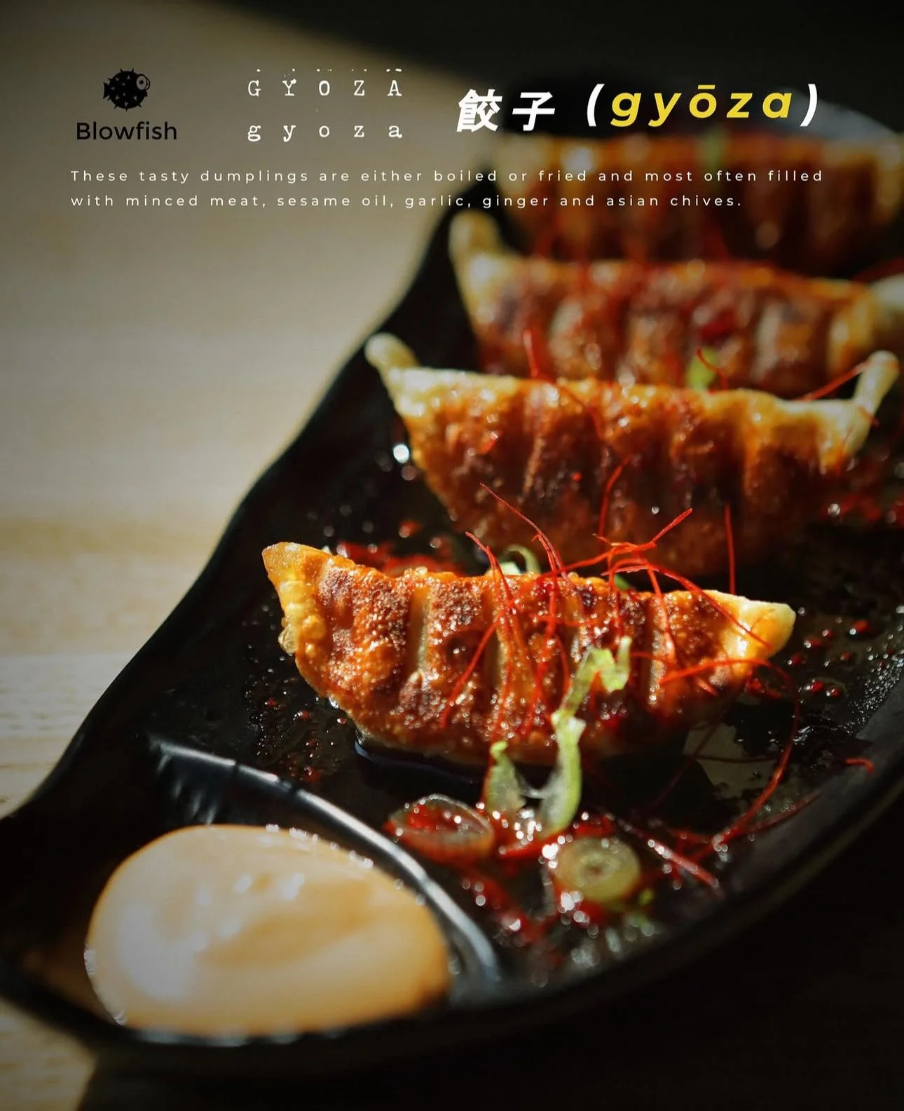 Close-up of a black plate with three gyoza dumplings garnished with red chili threads and shredded scallions, served with dipping sauce on the side.