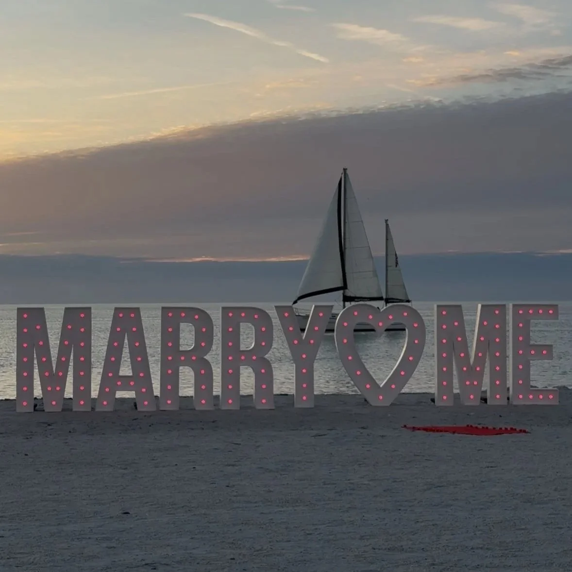 5 FT LARGE LED COLOR CHANGING "MARRY ME" MARQUEE LETTERS PLUS A 5 FT HEART MARQUEE SITTING ON A BEACH