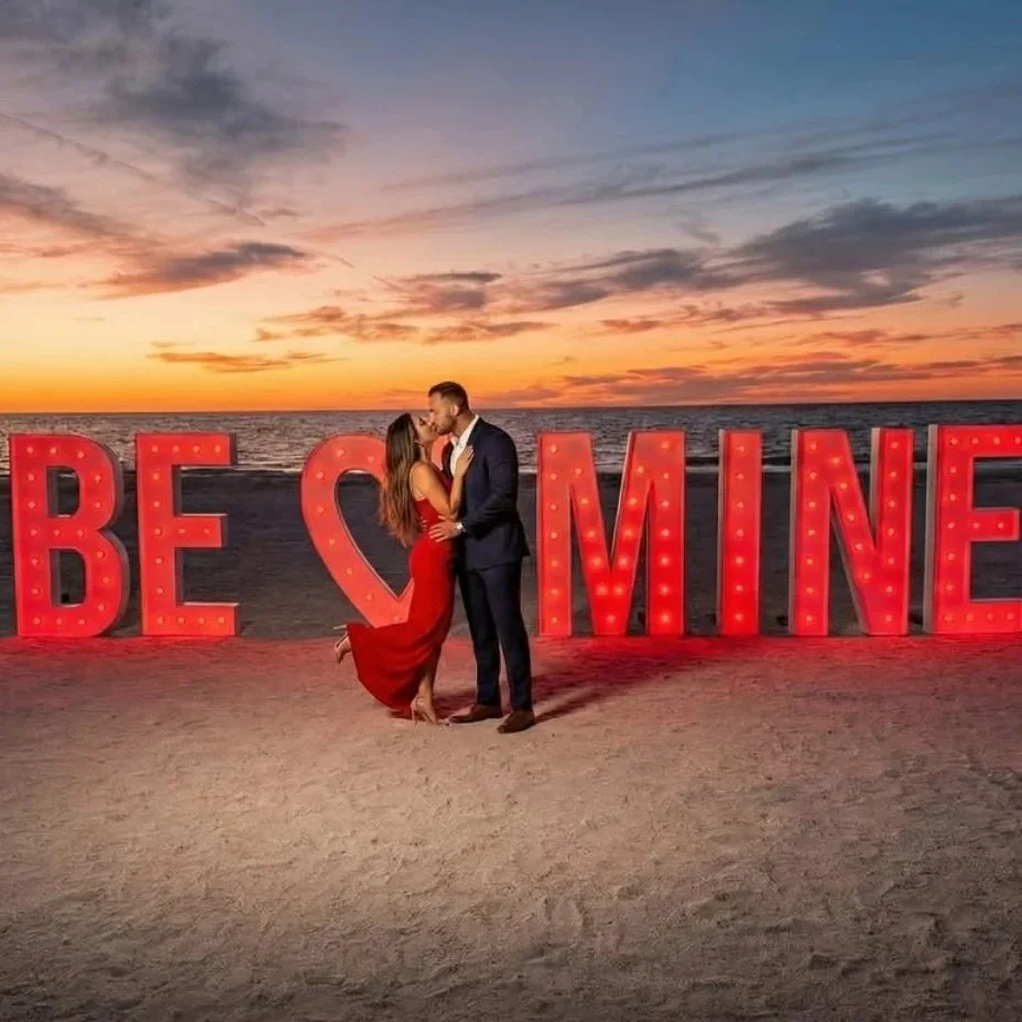 PREMIUM 5FT ILLUMINATED BE MINE MARQUEE LETTERS ON THE BEACH AT SUNSET, CREATING A ROMANTIC ENGAGEMENT PROPOSAL. STARTING AT $85 PER LETTER OR $75 EACH FOR 5+ RENTALS.