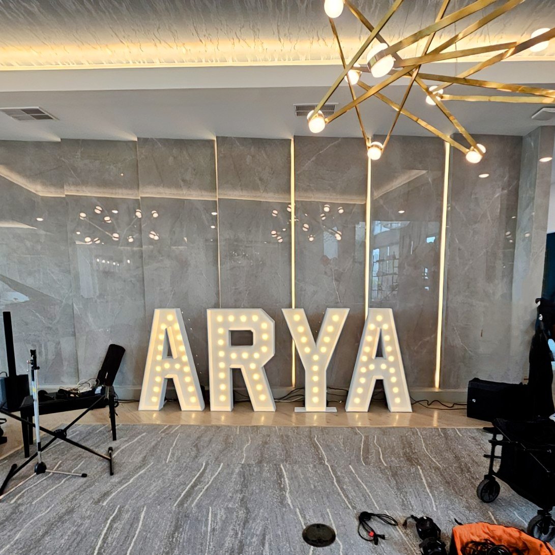 Large 4 ft wooden illuminated marquee letters spelling 'ARYA' for condominium grand opening.