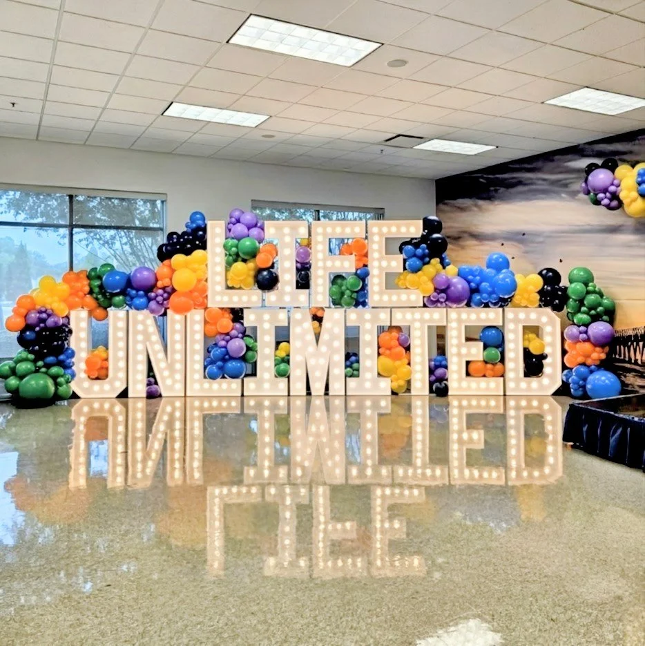 DOUBLE STACKED LARGE MARQUEE LETTER SET UP WITH COLORFUL BALLOON GARLAND