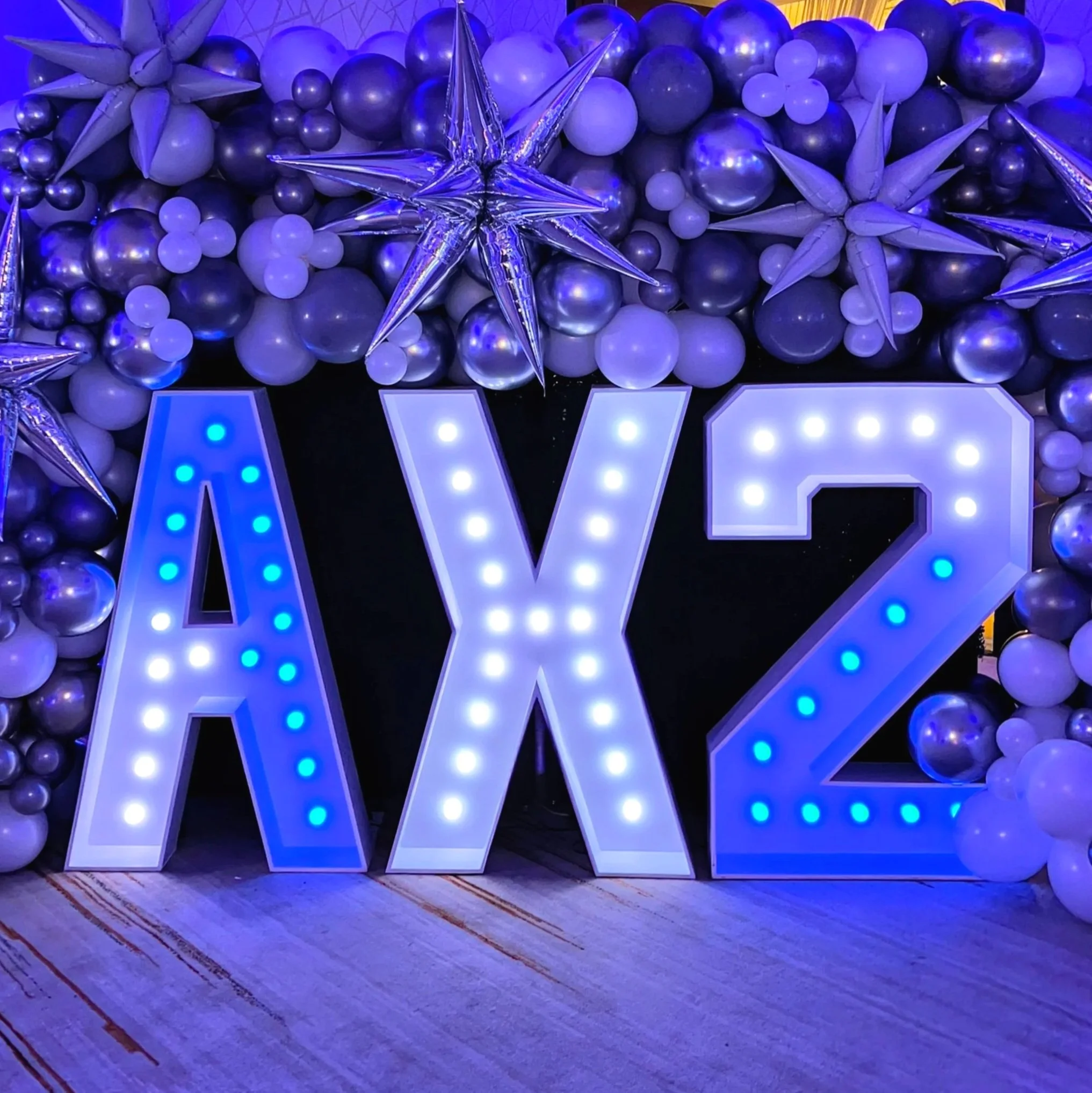 Decorative arrangement of balloons for the AX2 space launch party, illuminated LED color changing lighted large letter and number decorations.