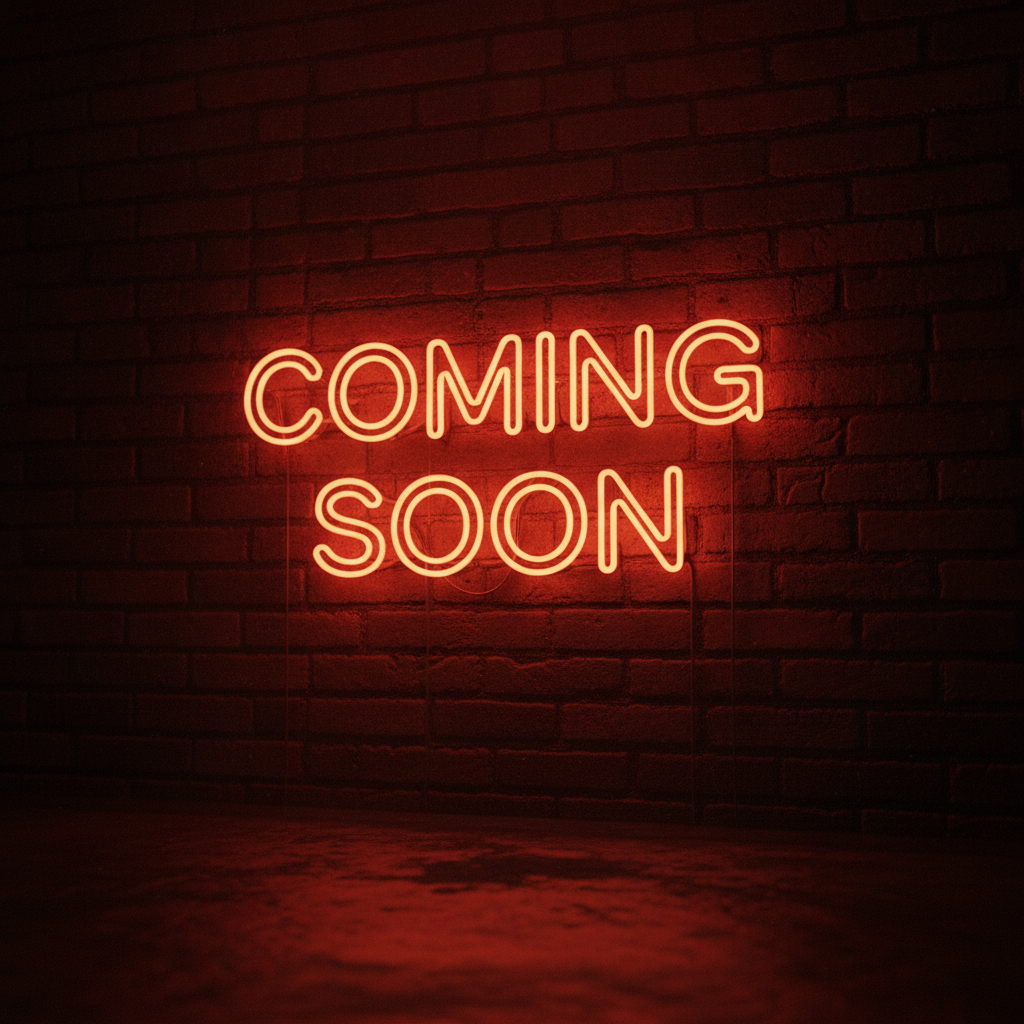 Neon sign on a brick wall that says 'Coming Soon' in glowing orange letters.
