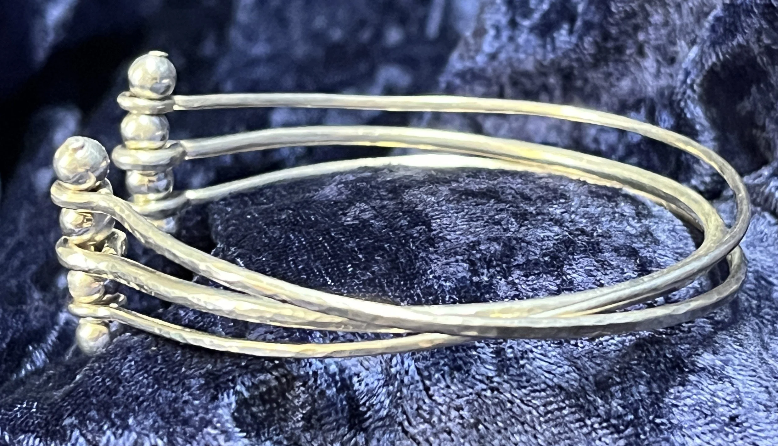 Sterling silver bracelet laying on a blue background.
