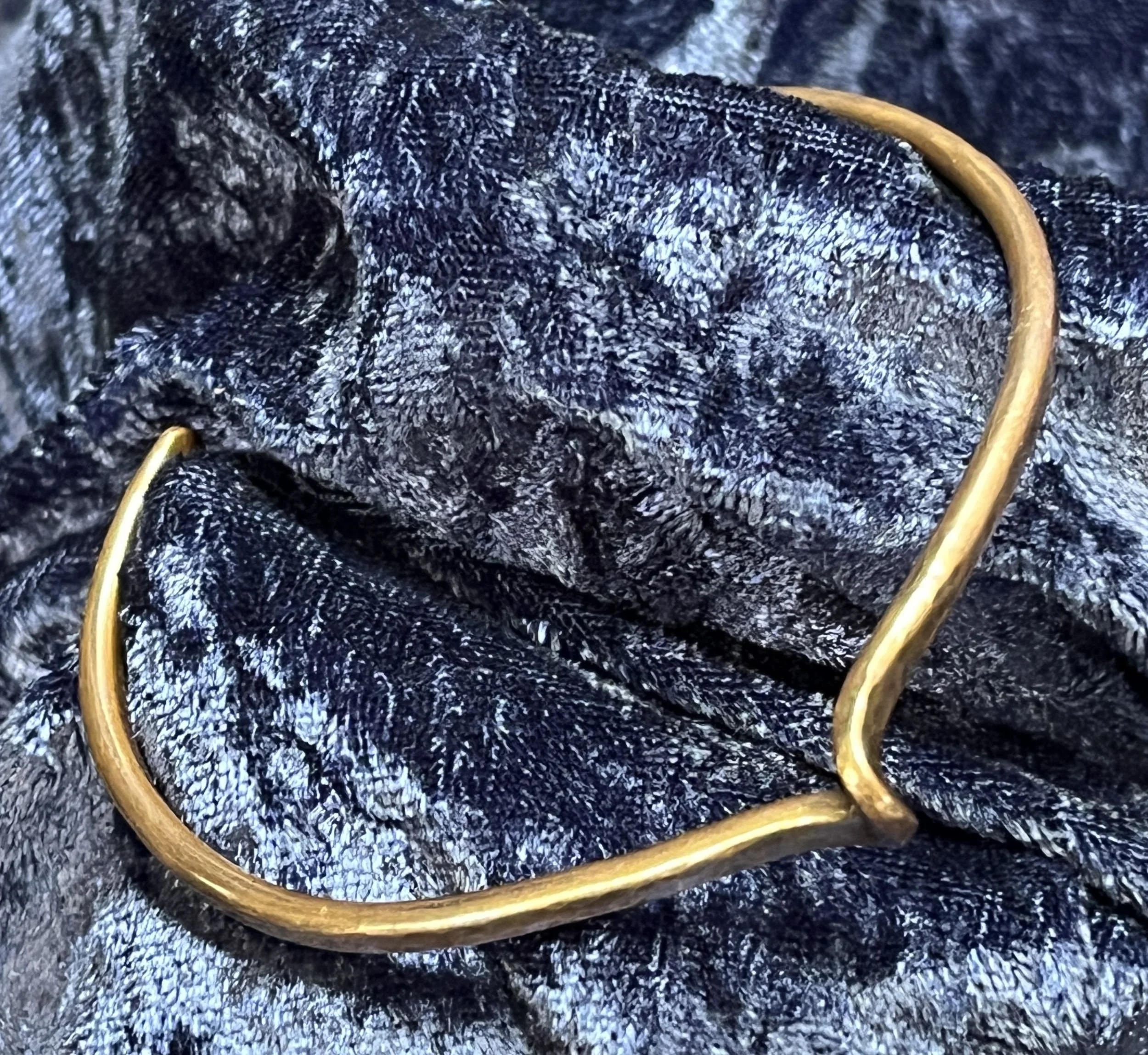 Hand-Forged Copper Twist Cuff Bracelet on blue background