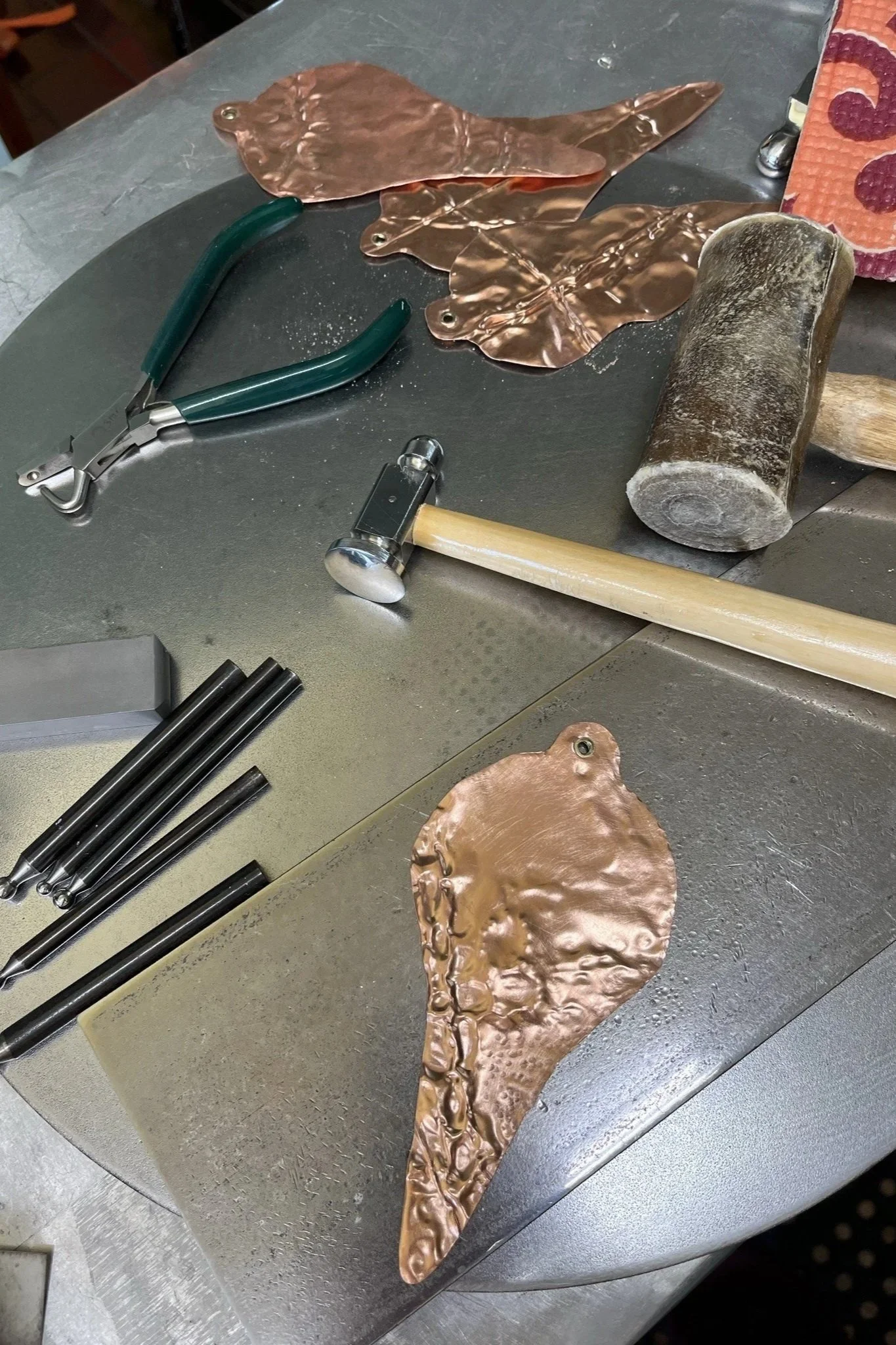 Copper Christmas ornaments are being created, using the metal folding technique.